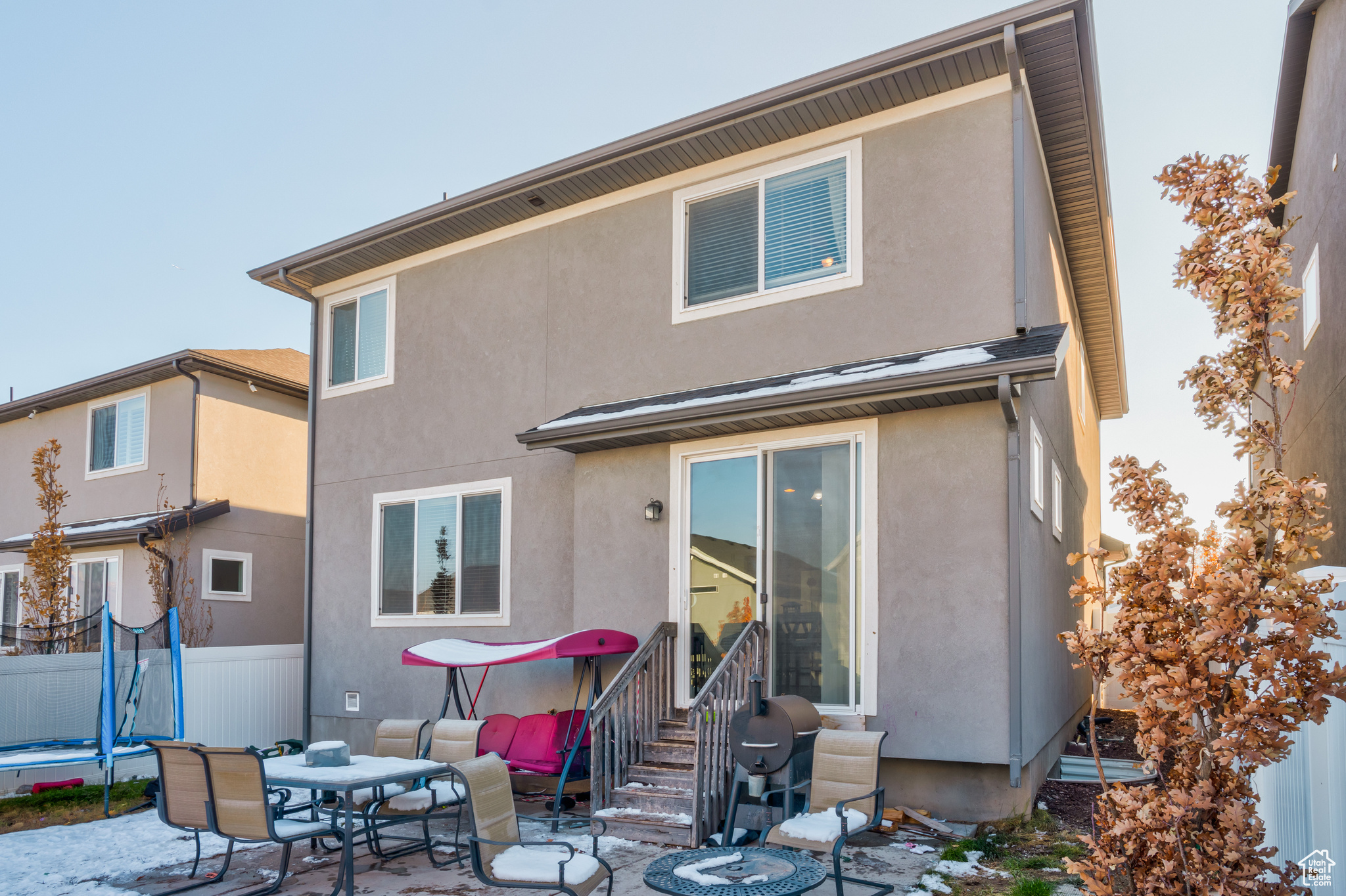 Rear view of property with a trampoline and a patio area