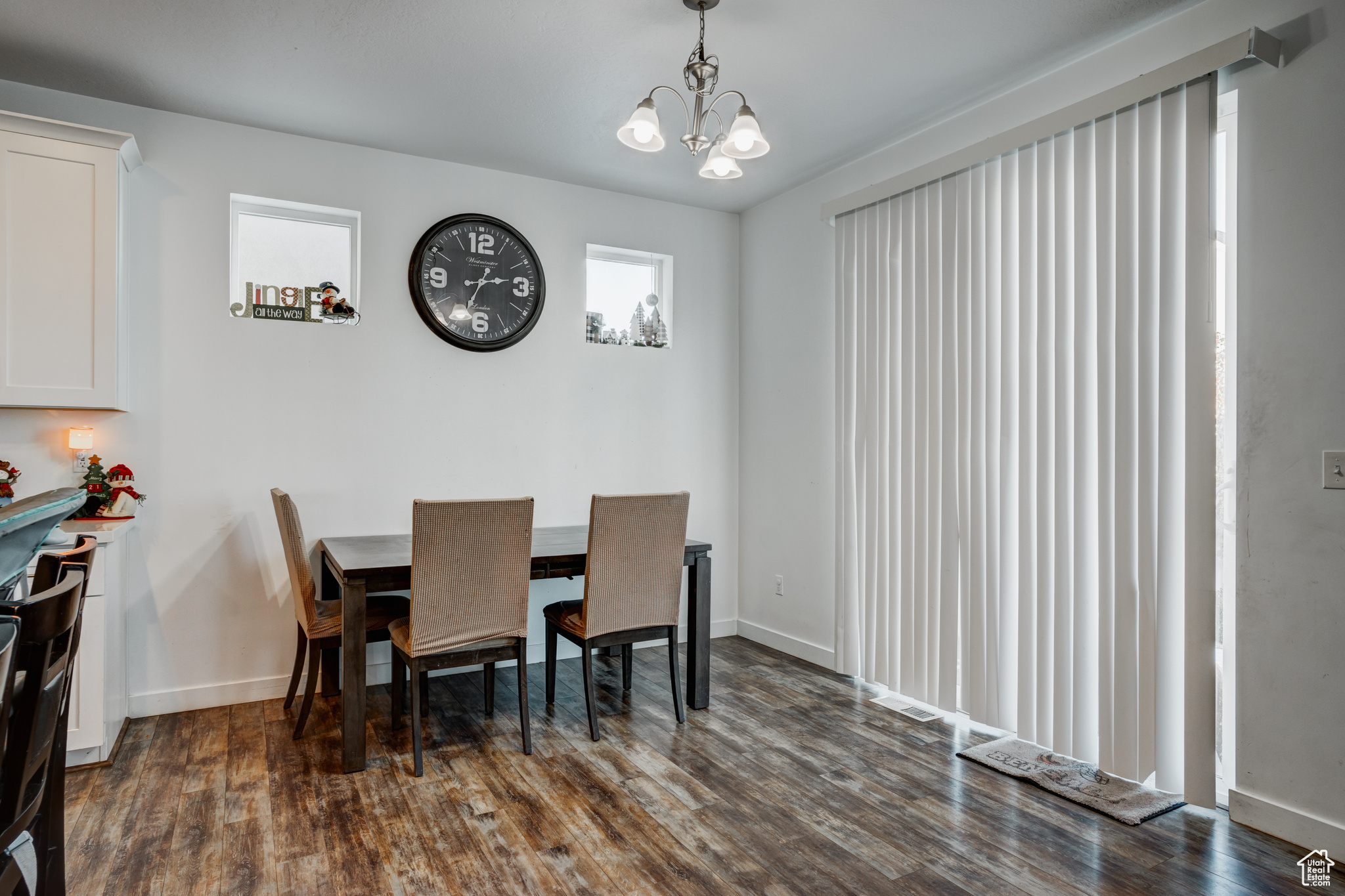 Dining room with plenty of natural light, dark hardwood / wood-style floors, and an inviting chandelier