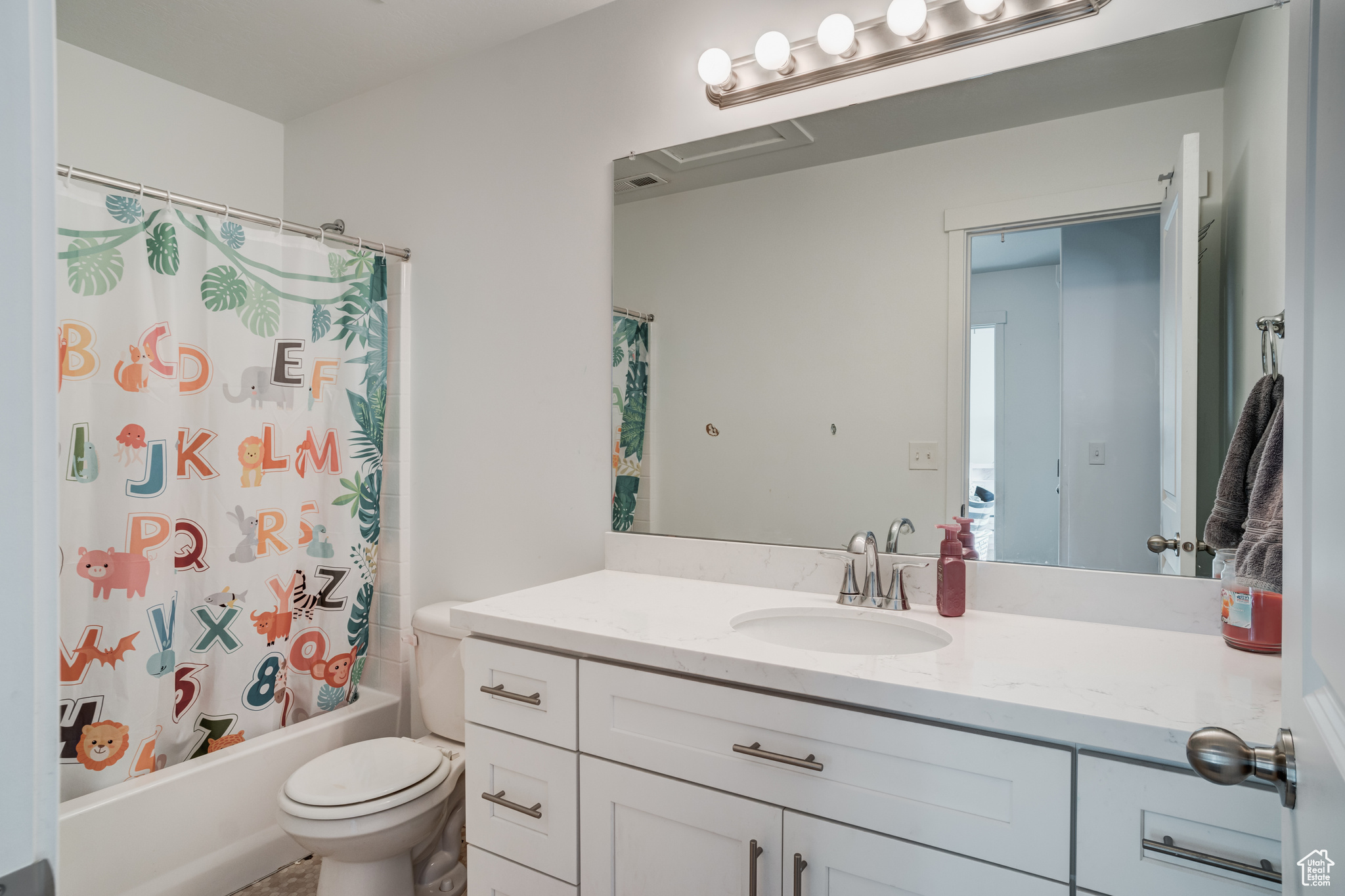 Full bathroom featuring shower / bath combo, toilet, and vanity