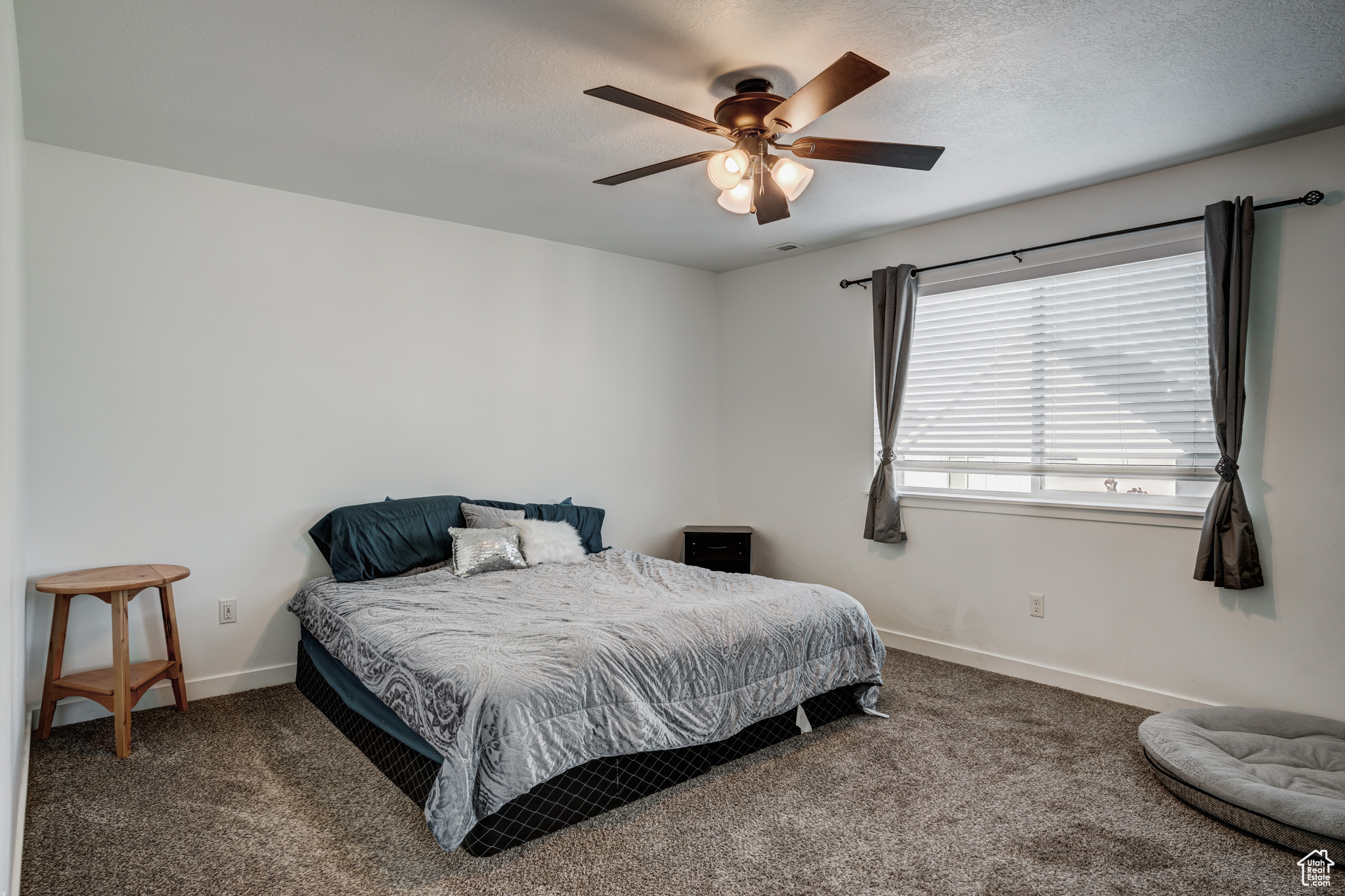 Bedroom featuring carpet, a textured ceiling, and ceiling fan