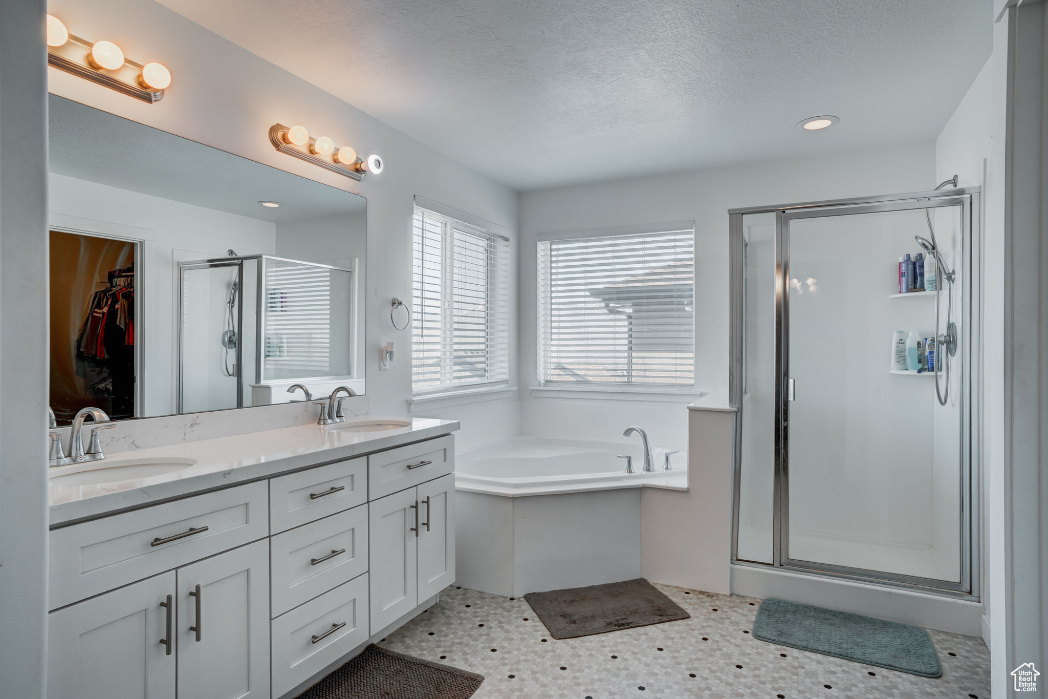 Bathroom with separate shower and tub, vanity, and a textured ceiling