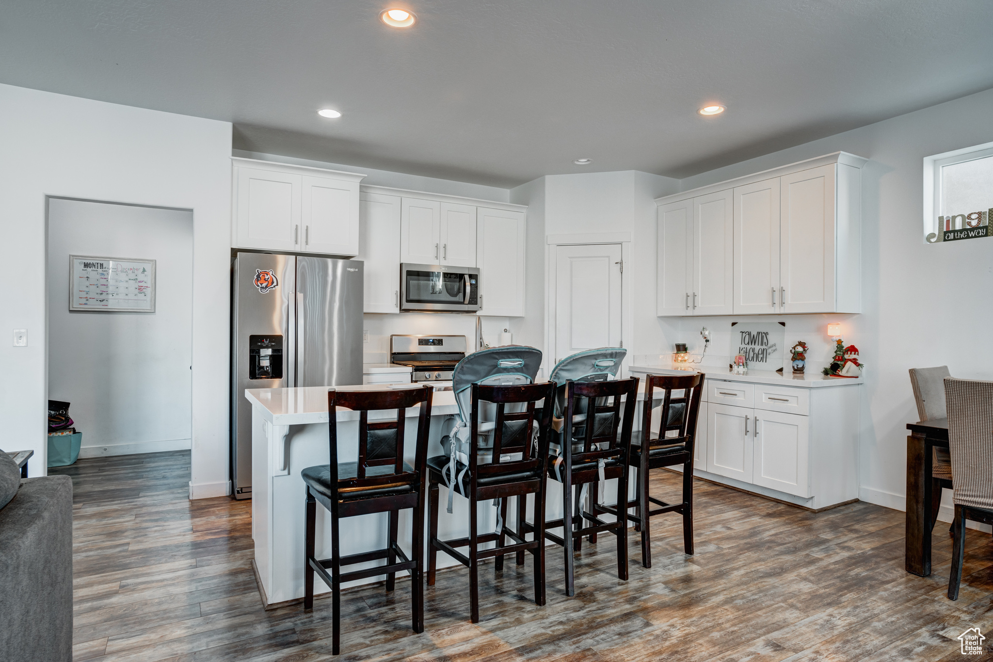 Kitchen featuring white cabinets, a center island, dark wood-type flooring, and appliances with stainless steel finishes