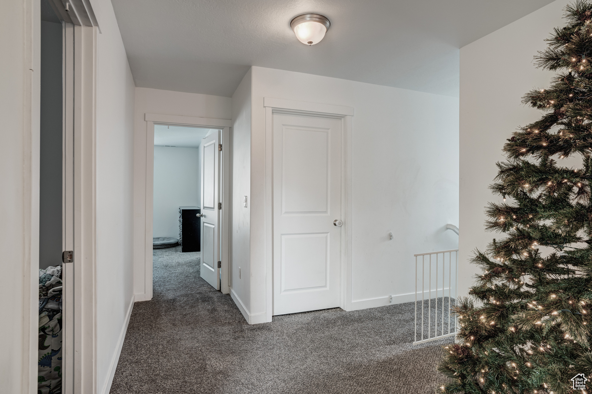 Hall featuring dark colored carpet