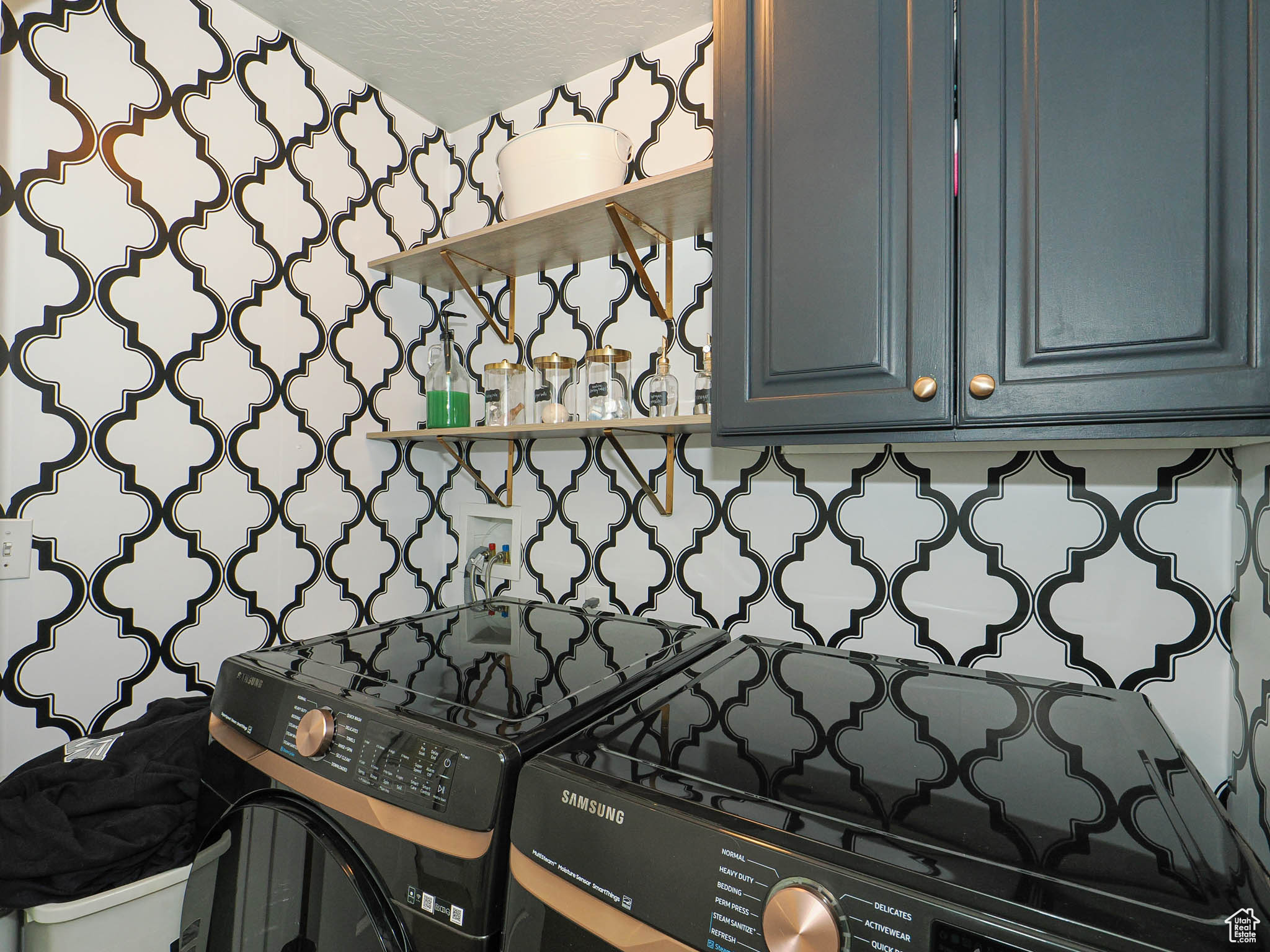 Interior details with black range oven, decorative backsplash, and washer and dryer