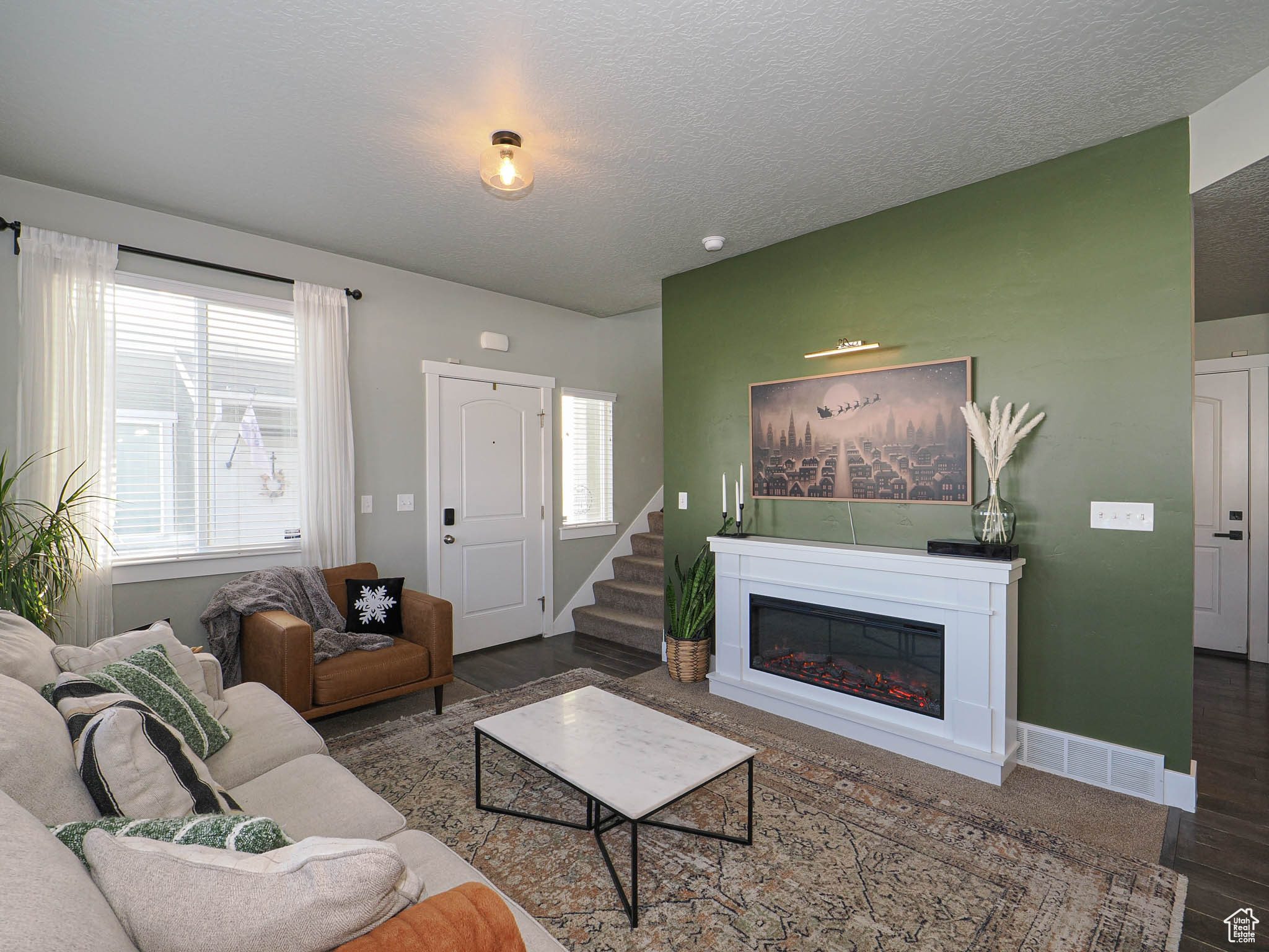 Living room with plenty of natural light, dark hardwood / wood-style flooring, and a textured ceiling