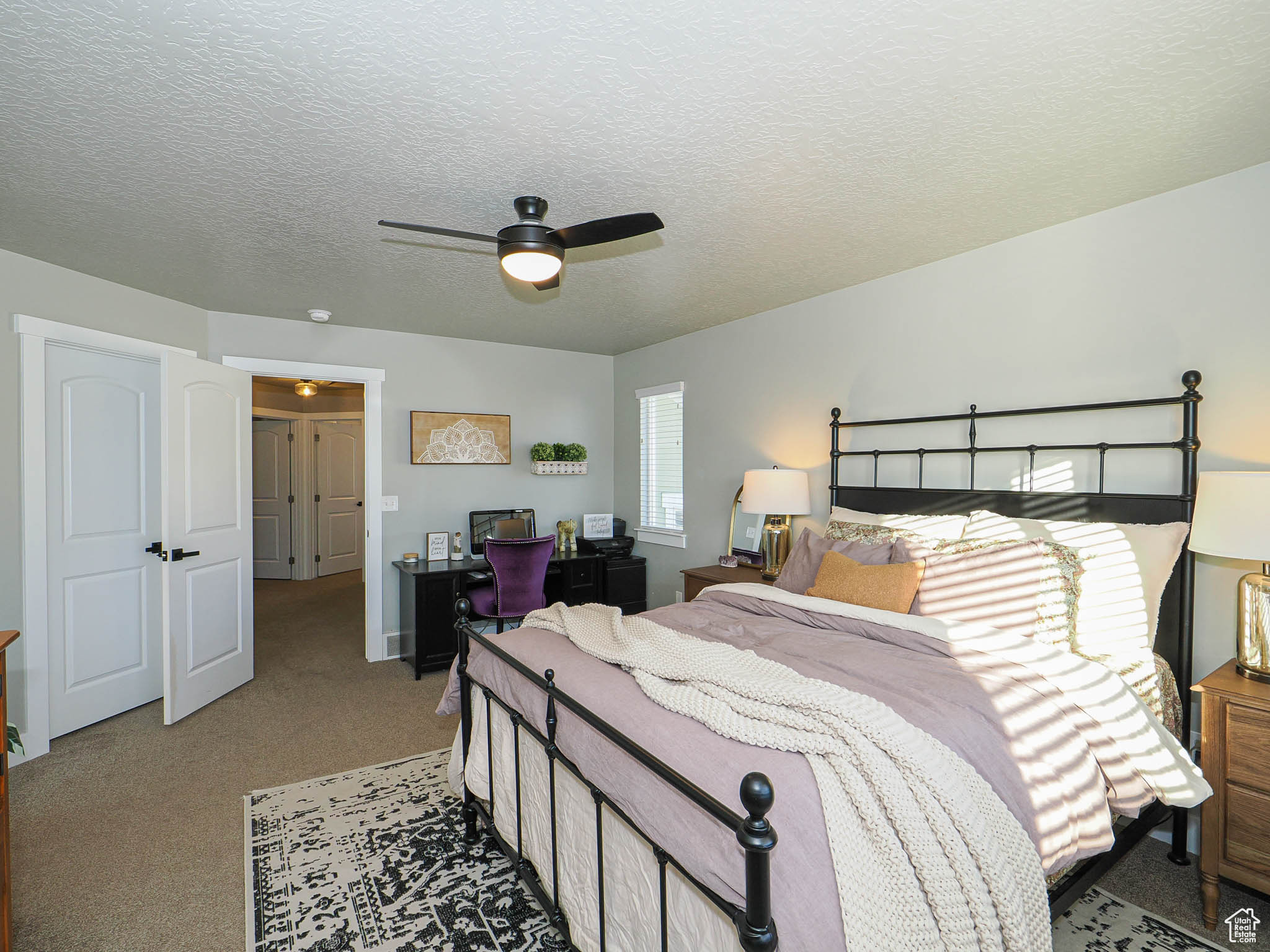 Bedroom featuring ceiling fan, carpet, and a textured ceiling