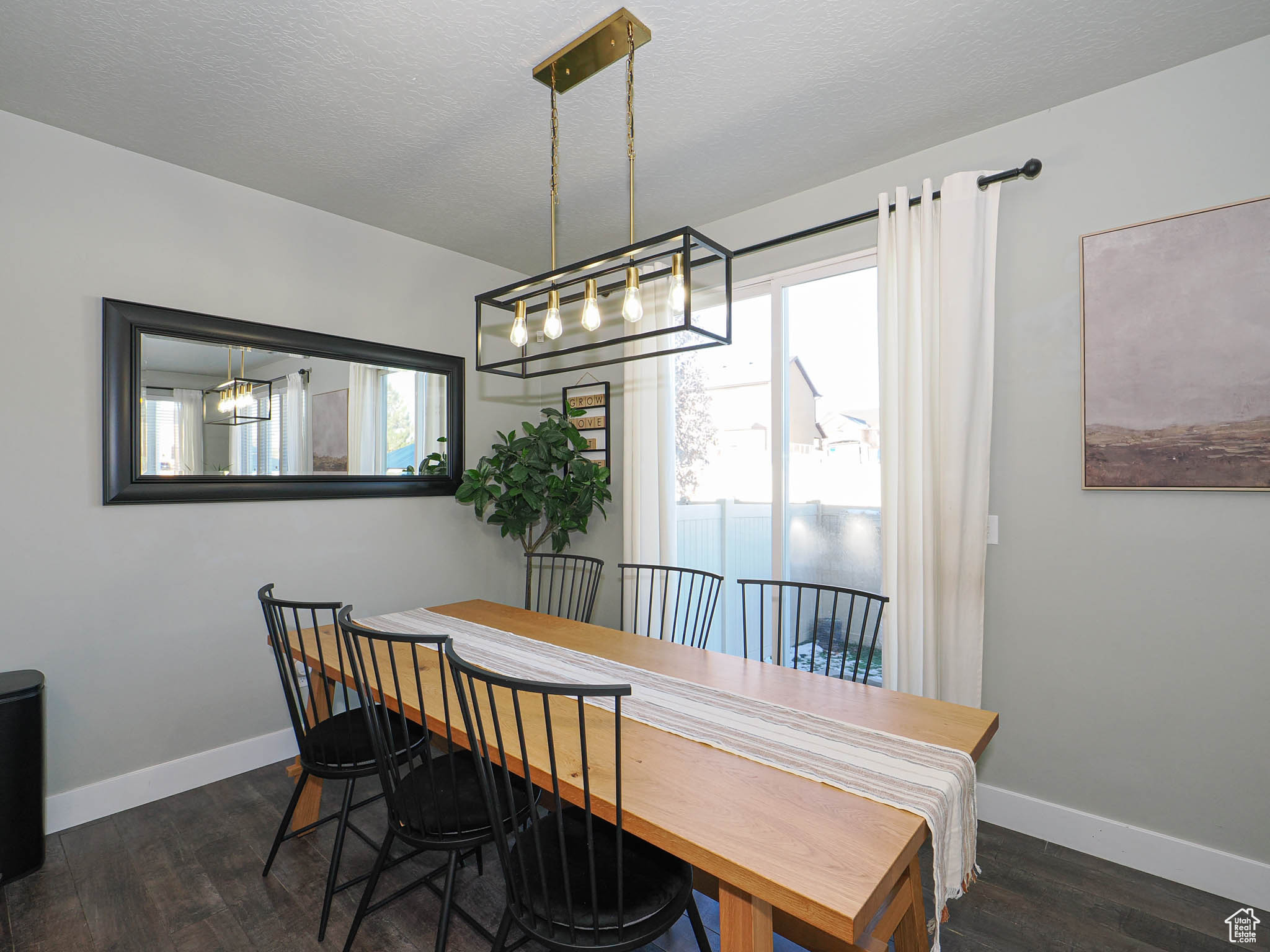 Dining area featuring a textured ceiling, an inviting chandelier, and dark wood-type flooring