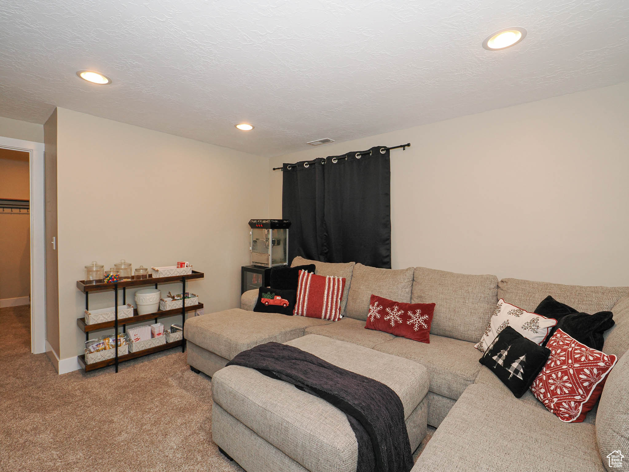 Carpeted bedroom featuring a textured ceiling, a spacious closet, and a closet