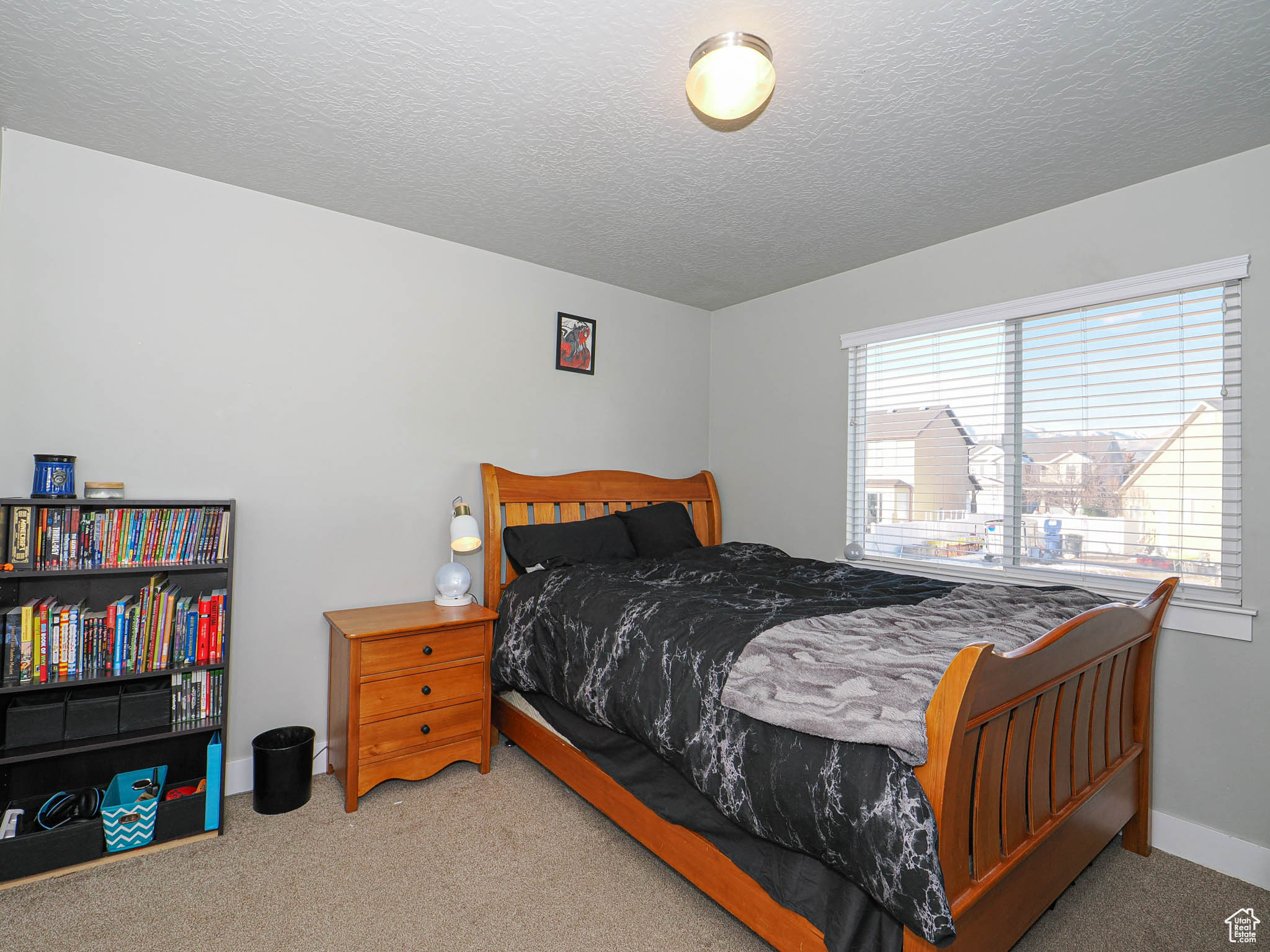 Bedroom with light carpet and a textured ceiling