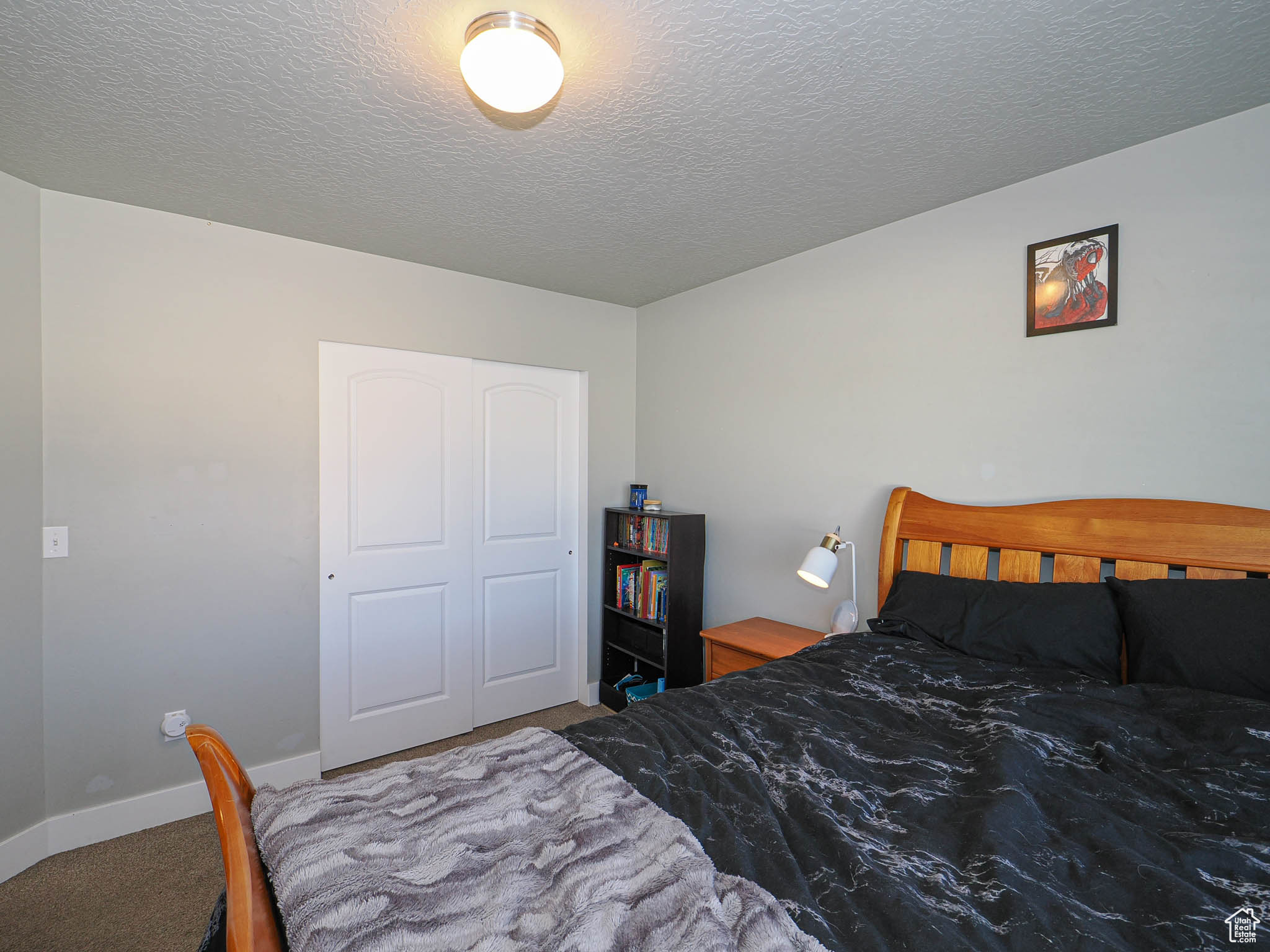 Carpeted bedroom with a textured ceiling