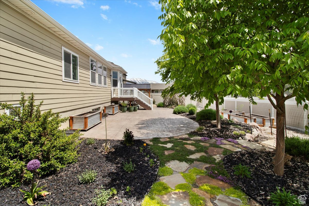 View of yard featuring a deck and a patio