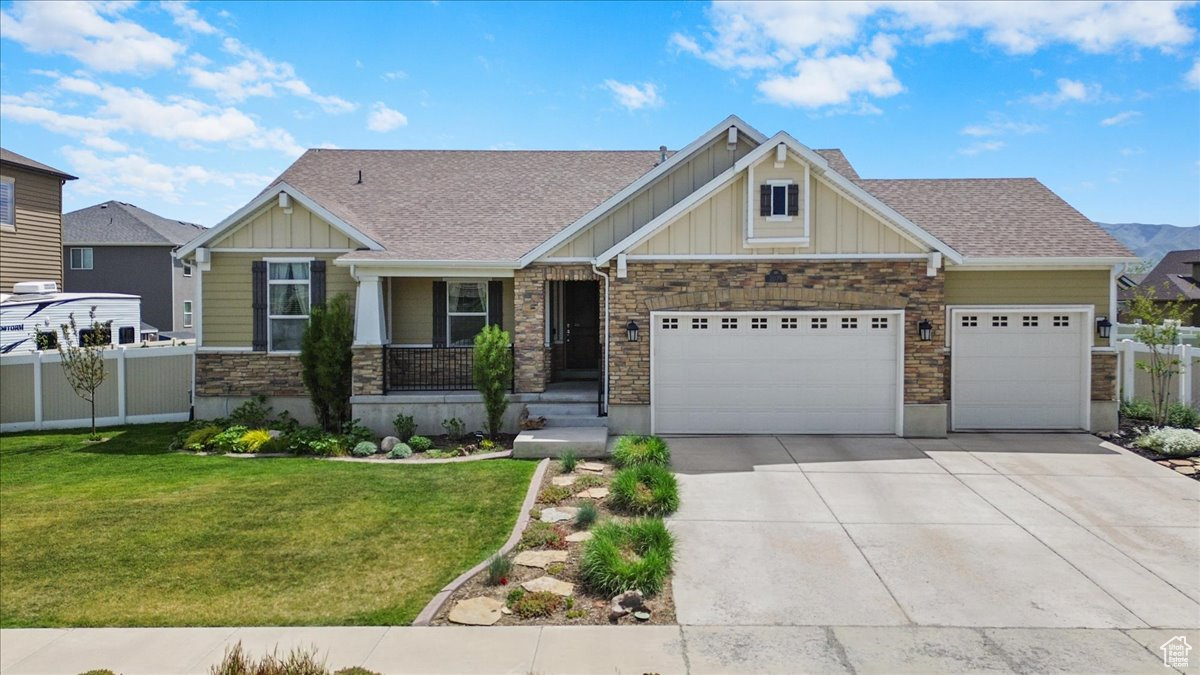 Craftsman inspired home featuring a 3 car garage and a front lawn