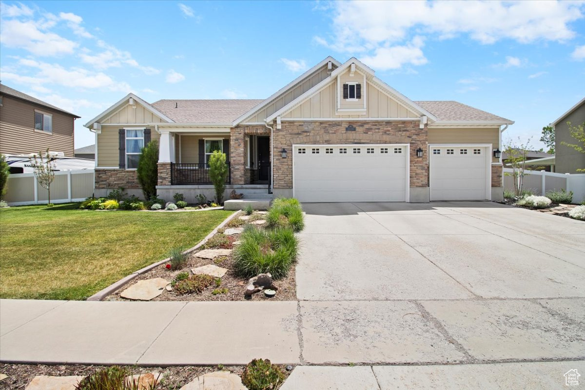 Craftsman inspired home with covered porch, a 3 car garage, and a front yard