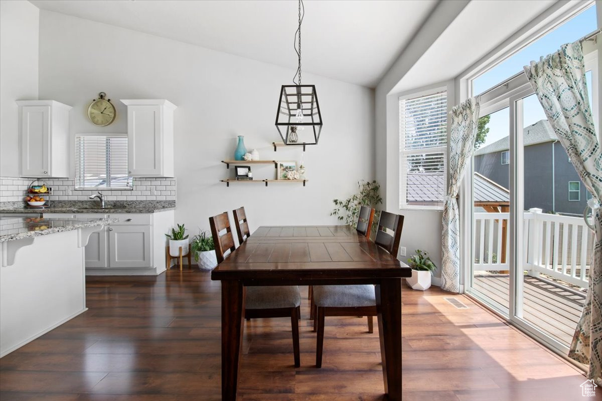 Dining area featuring dark hardwood / wood-style floors and lofted ceiling