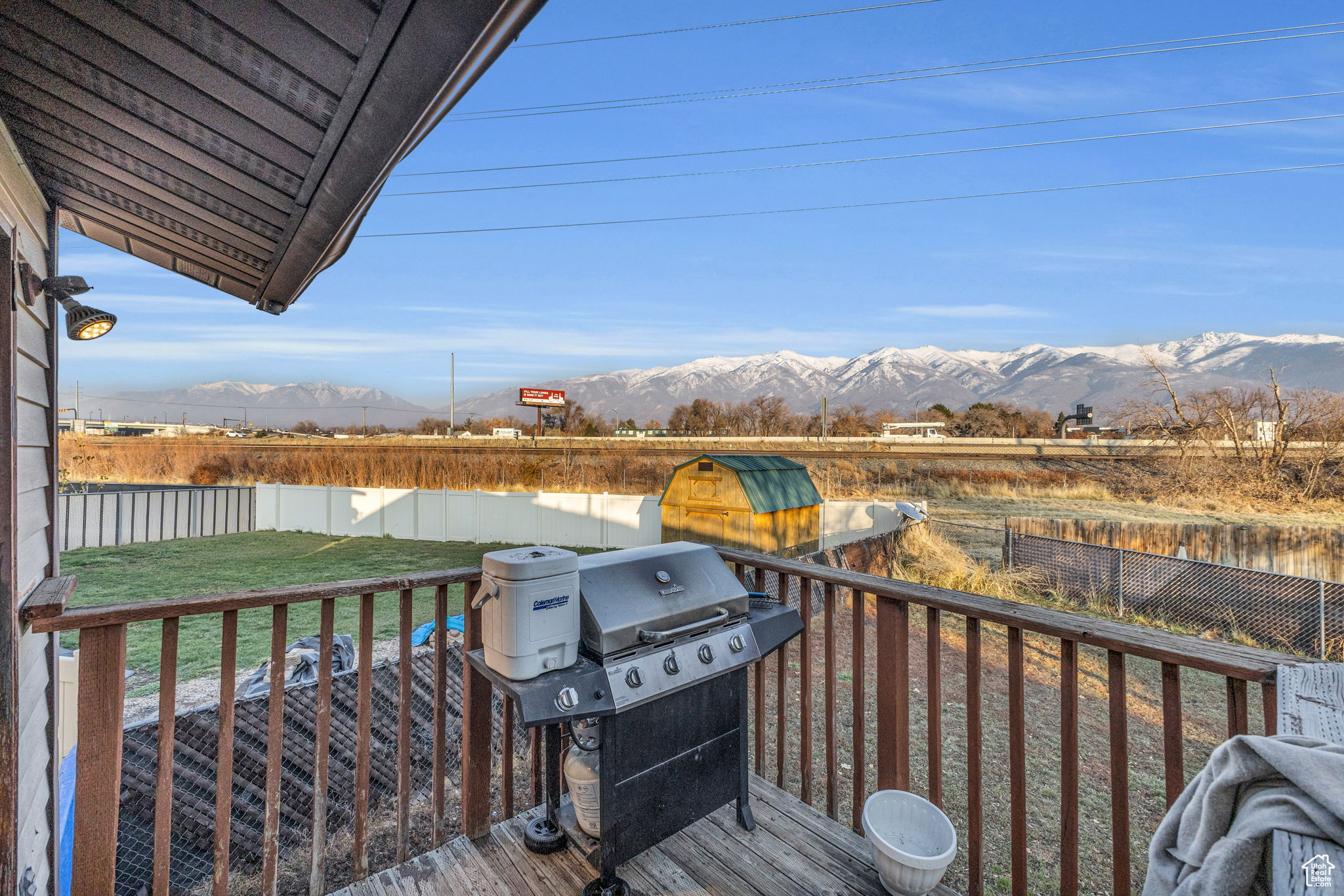 Wooden deck featuring a mountain view, a yard, and a grill