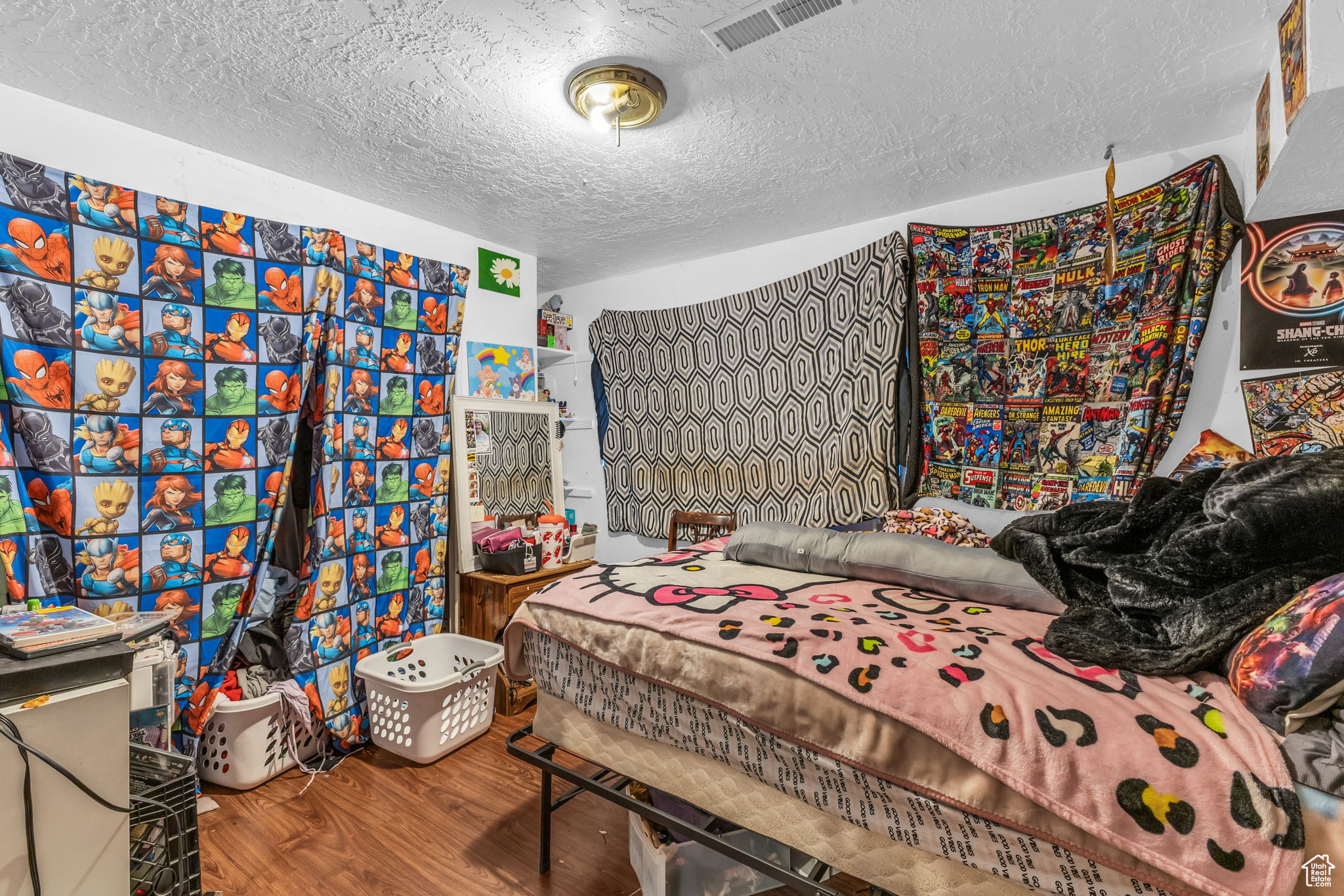 Bedroom with hardwood / wood-style floors and a textured ceiling