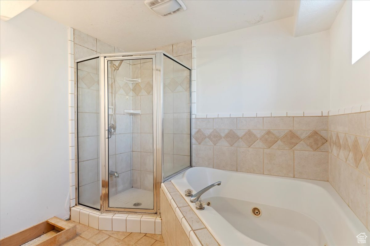 Bathroom with tile patterned floors and separate shower and tub