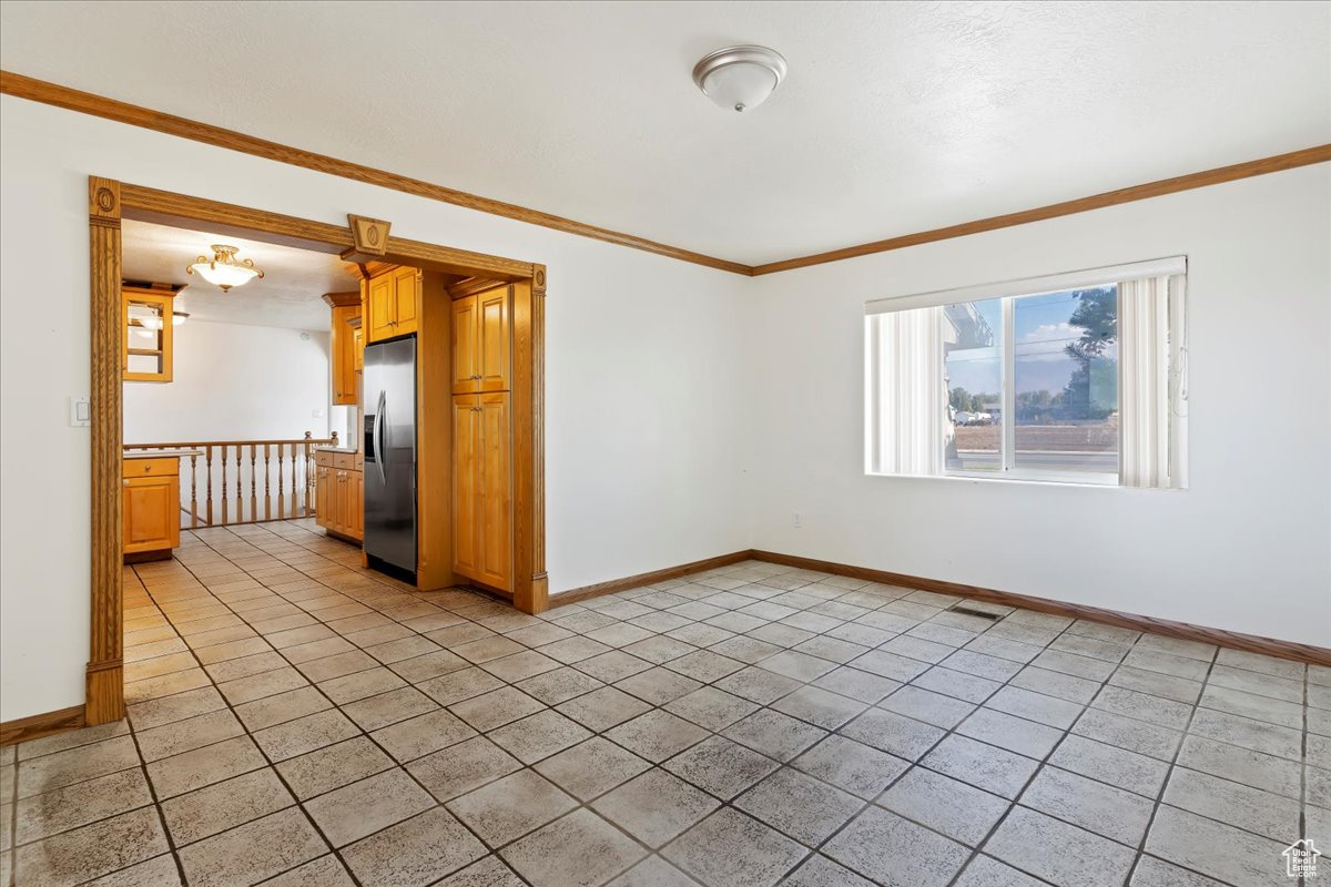 Tiled empty room with crown molding