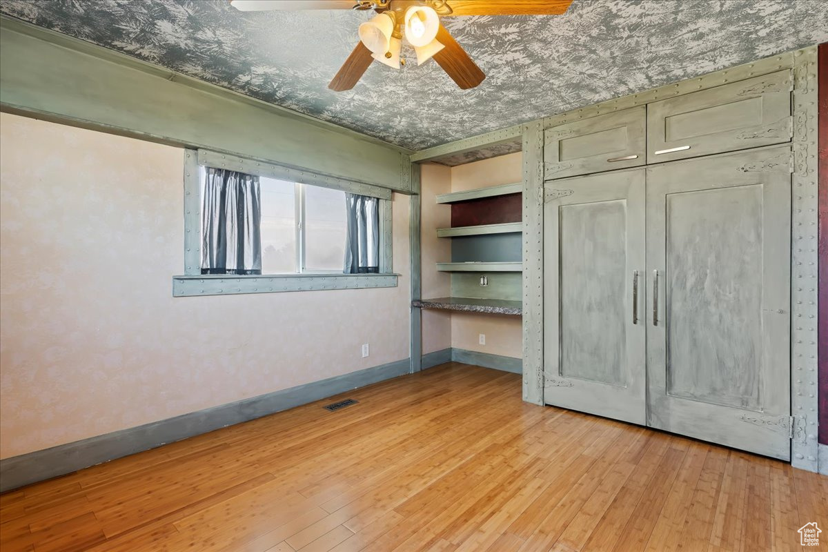 Unfurnished bedroom with ceiling fan and light hardwood / wood-style floors