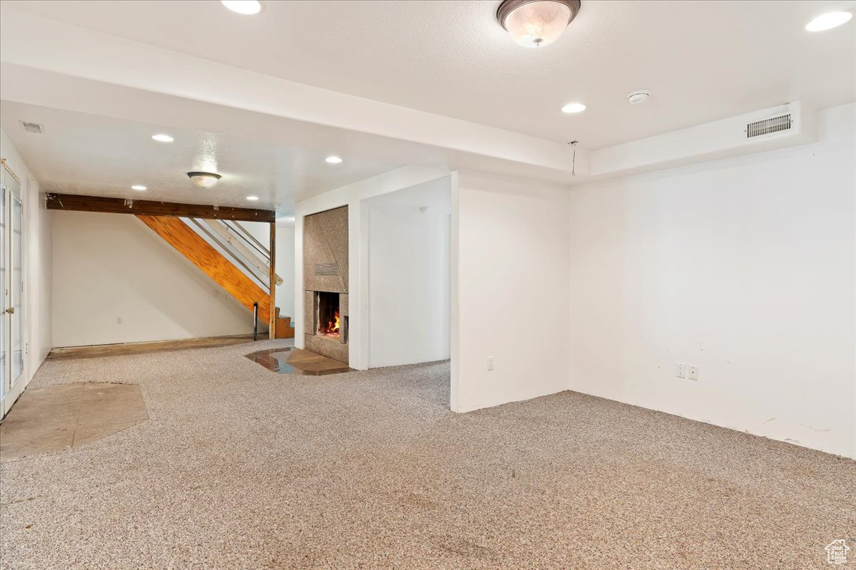 Basement featuring carpet and a fireplace