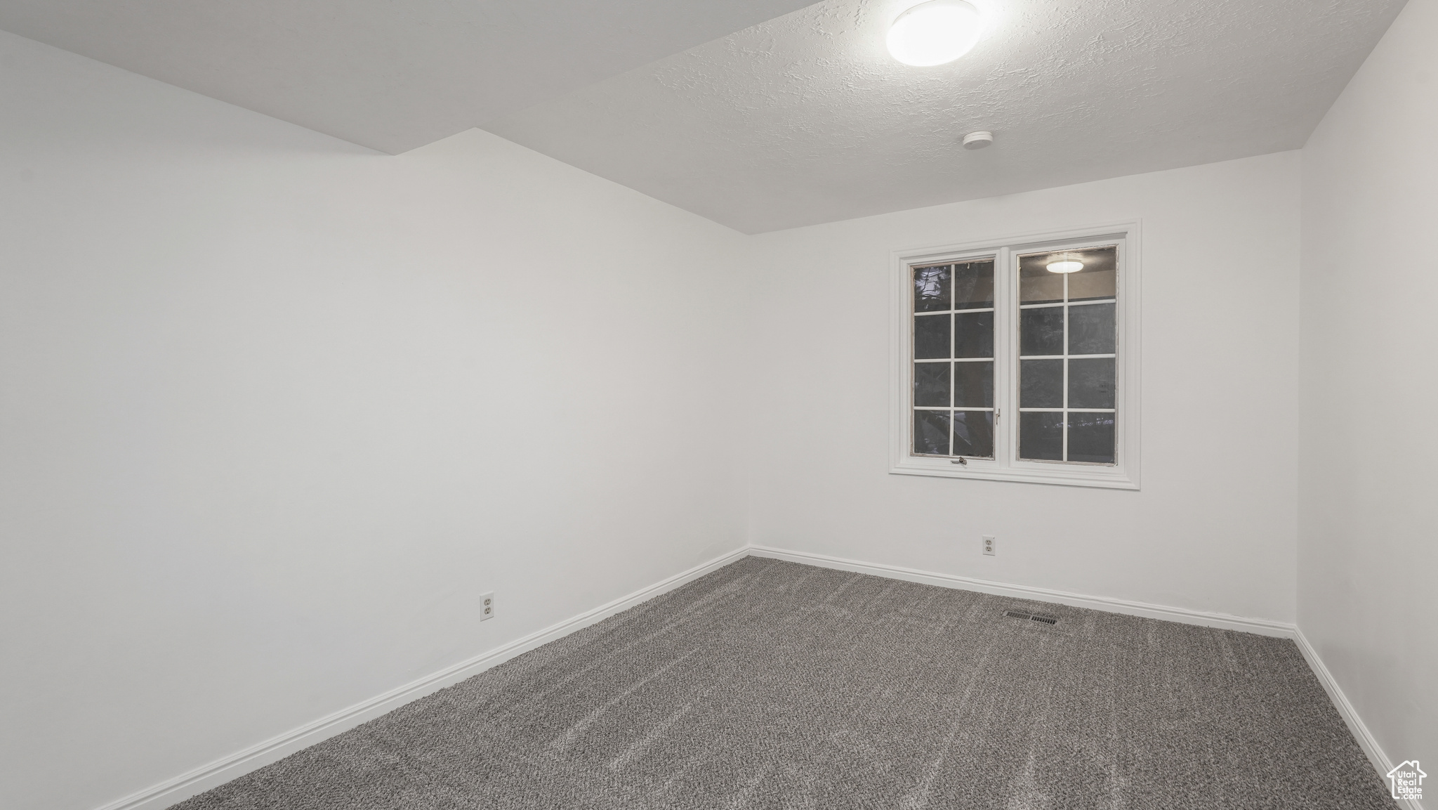 Spare room with carpet and a textured ceiling