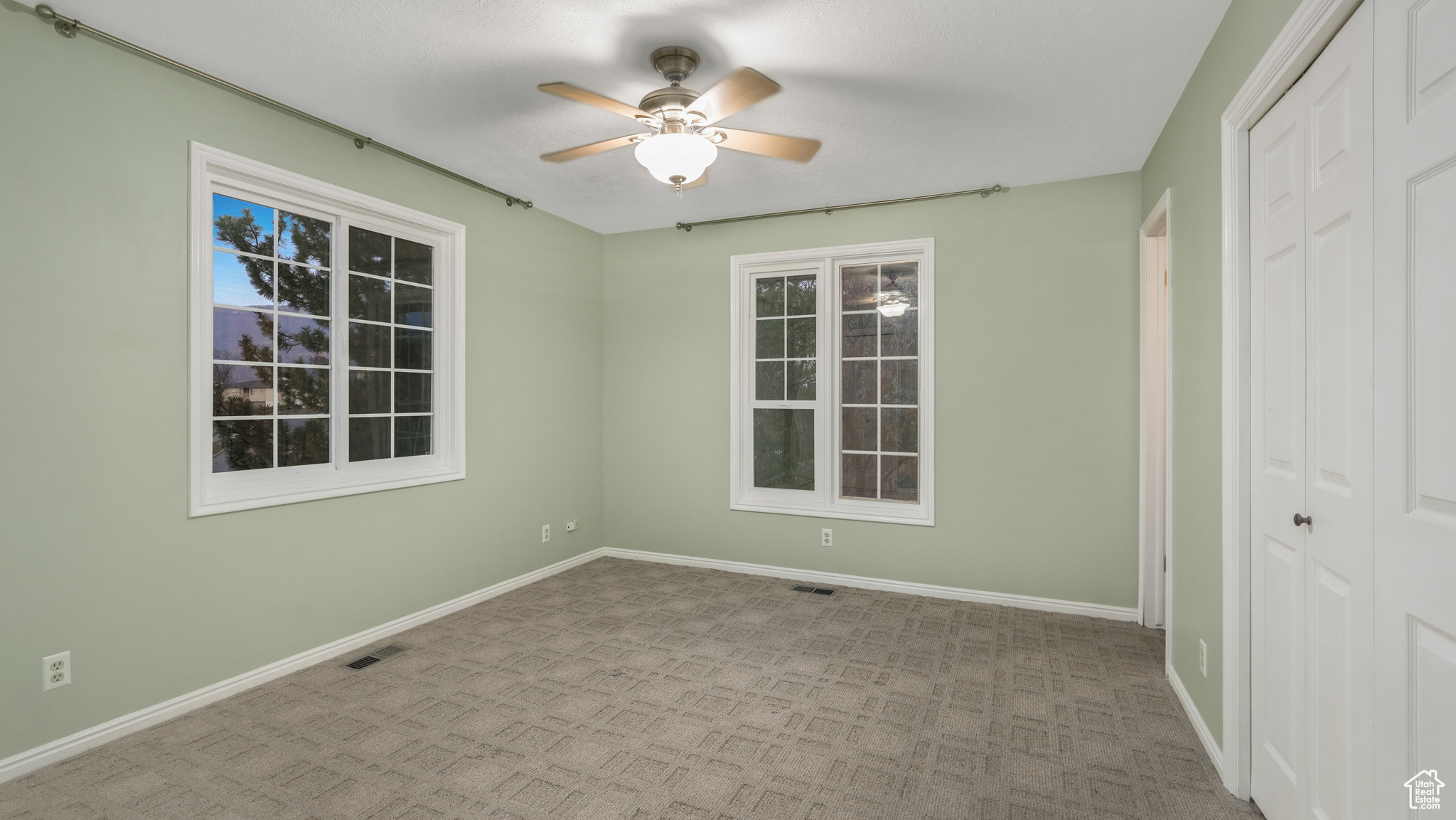 Unfurnished room featuring ceiling fan and light colored carpet