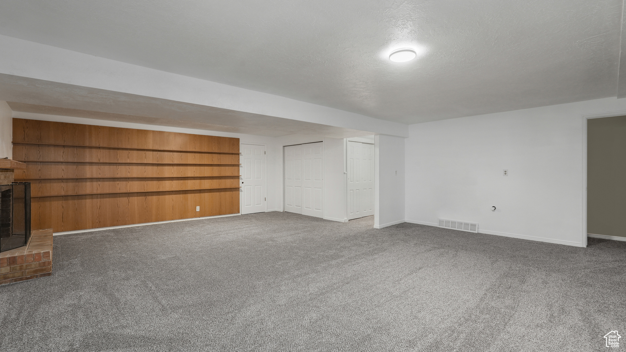 Basement featuring carpet, a fireplace, and a textured ceiling