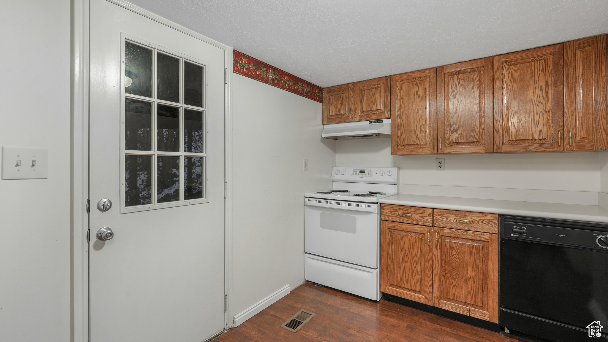 Kitchen featuring white electric range oven, dark hardwood / wood-style flooring, and black dishwasher