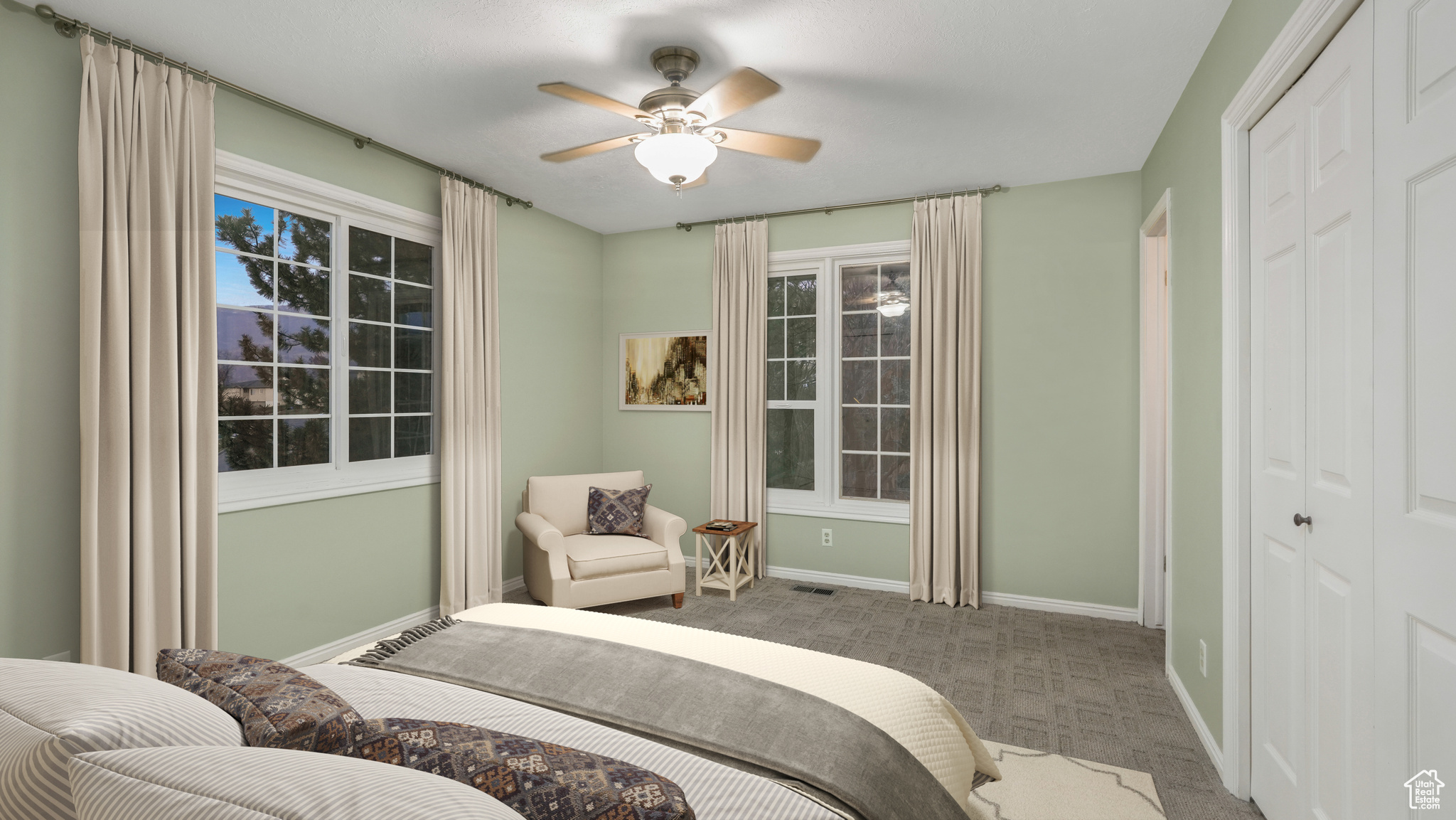 Carpeted bedroom featuring ceiling fan and a closet