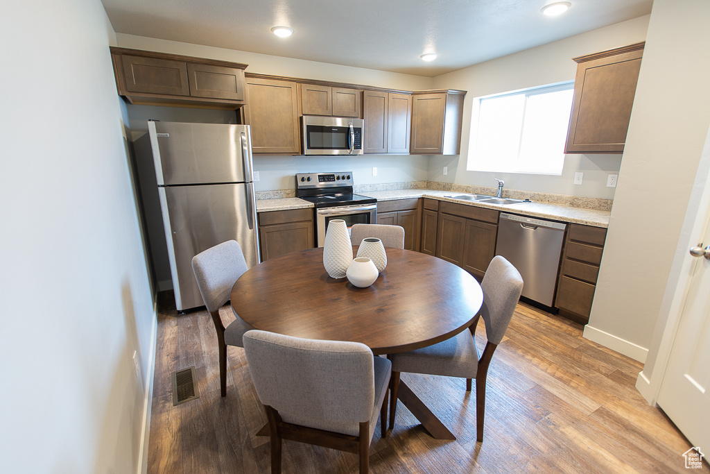 Kitchen with light wood-type flooring, stainless steel appliances, and sink