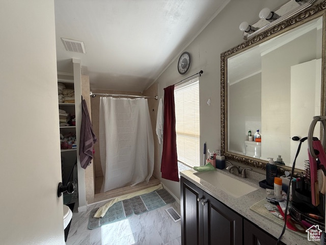 Bathroom featuring vanity, toilet, walk in shower, and vaulted ceiling