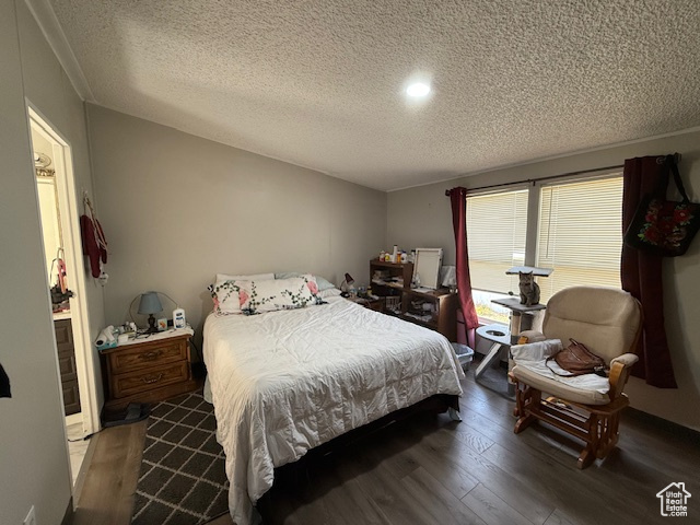 Bedroom featuring dark hardwood / wood-style flooring and a textured ceiling