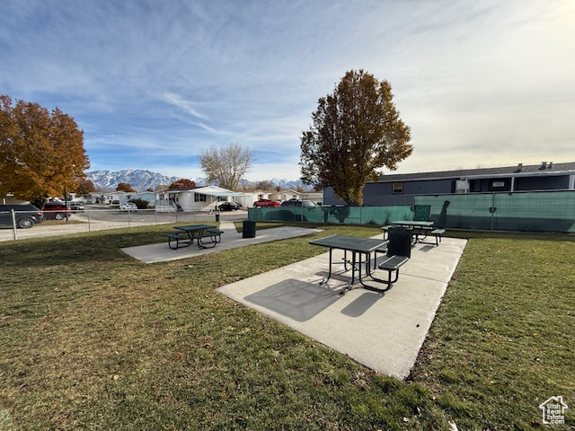 View of property's community featuring a mountain view and grass area