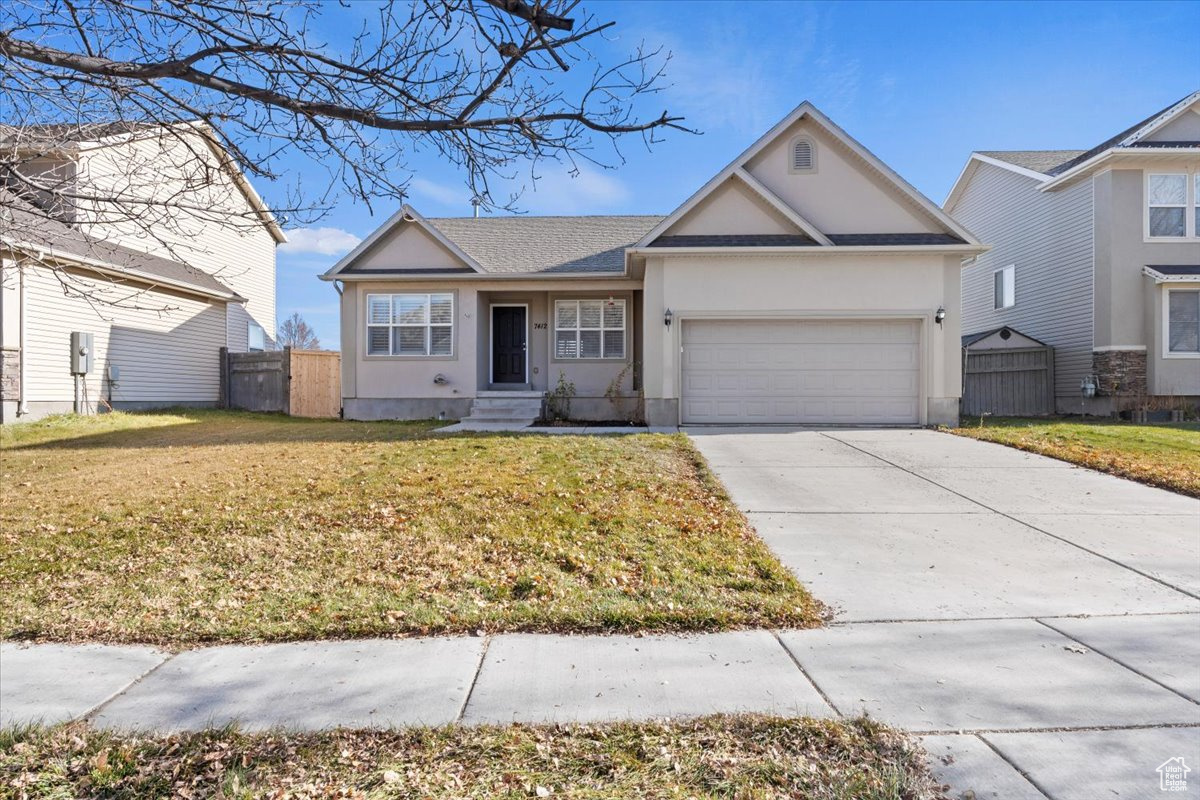 Ranch-style house with a garage and a front yard