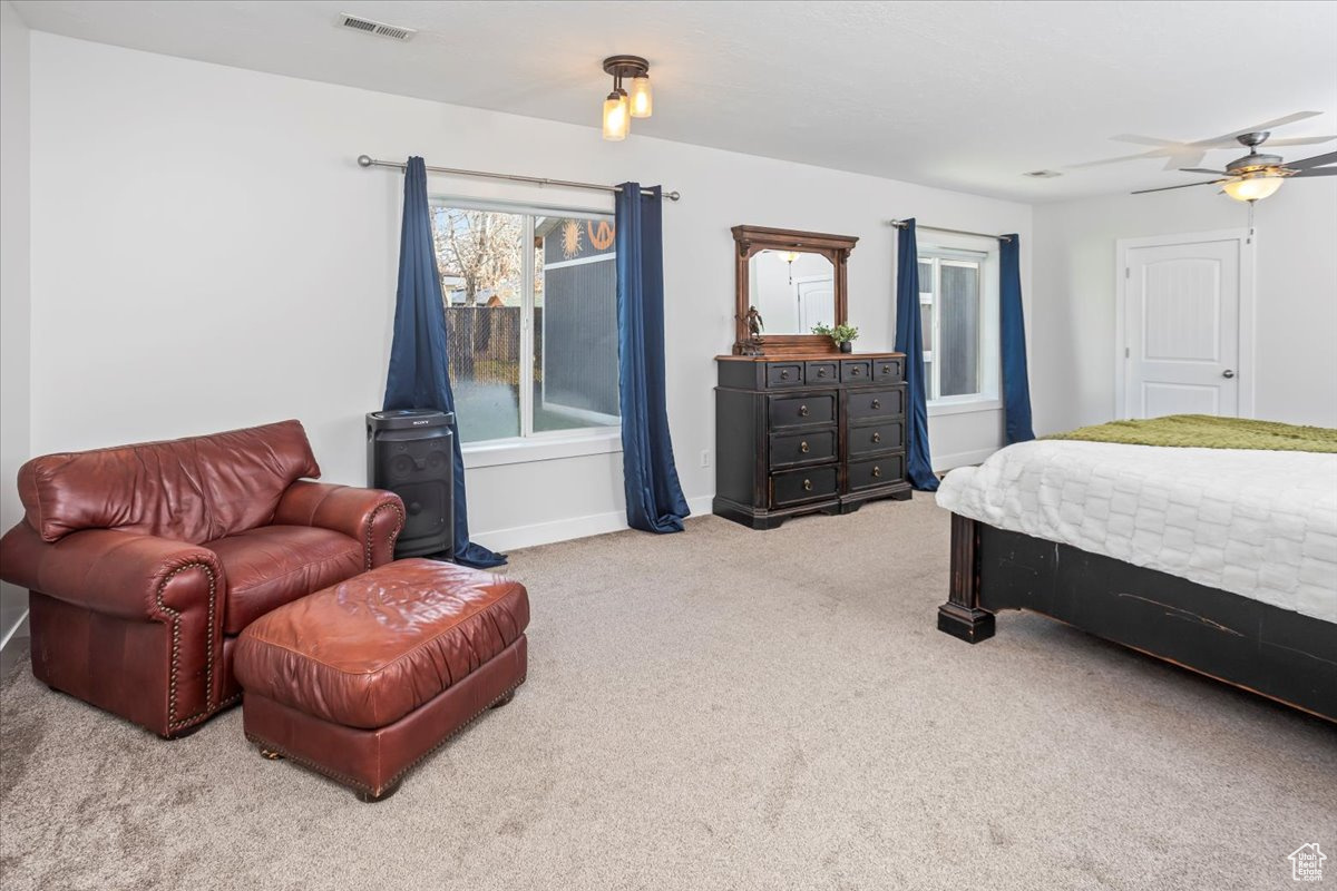 Carpeted bedroom featuring ceiling fan