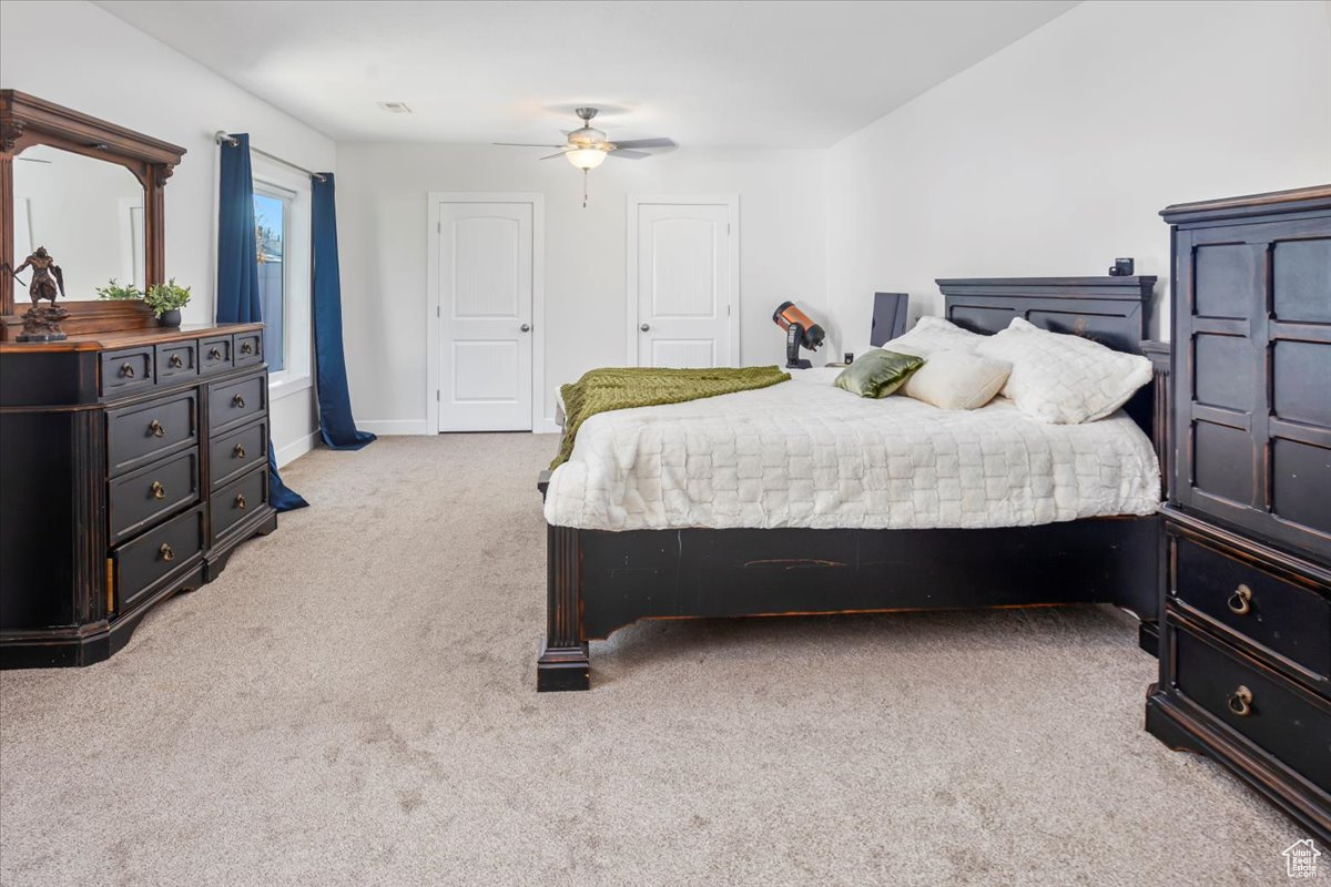 Bedroom featuring light carpet and ceiling fan