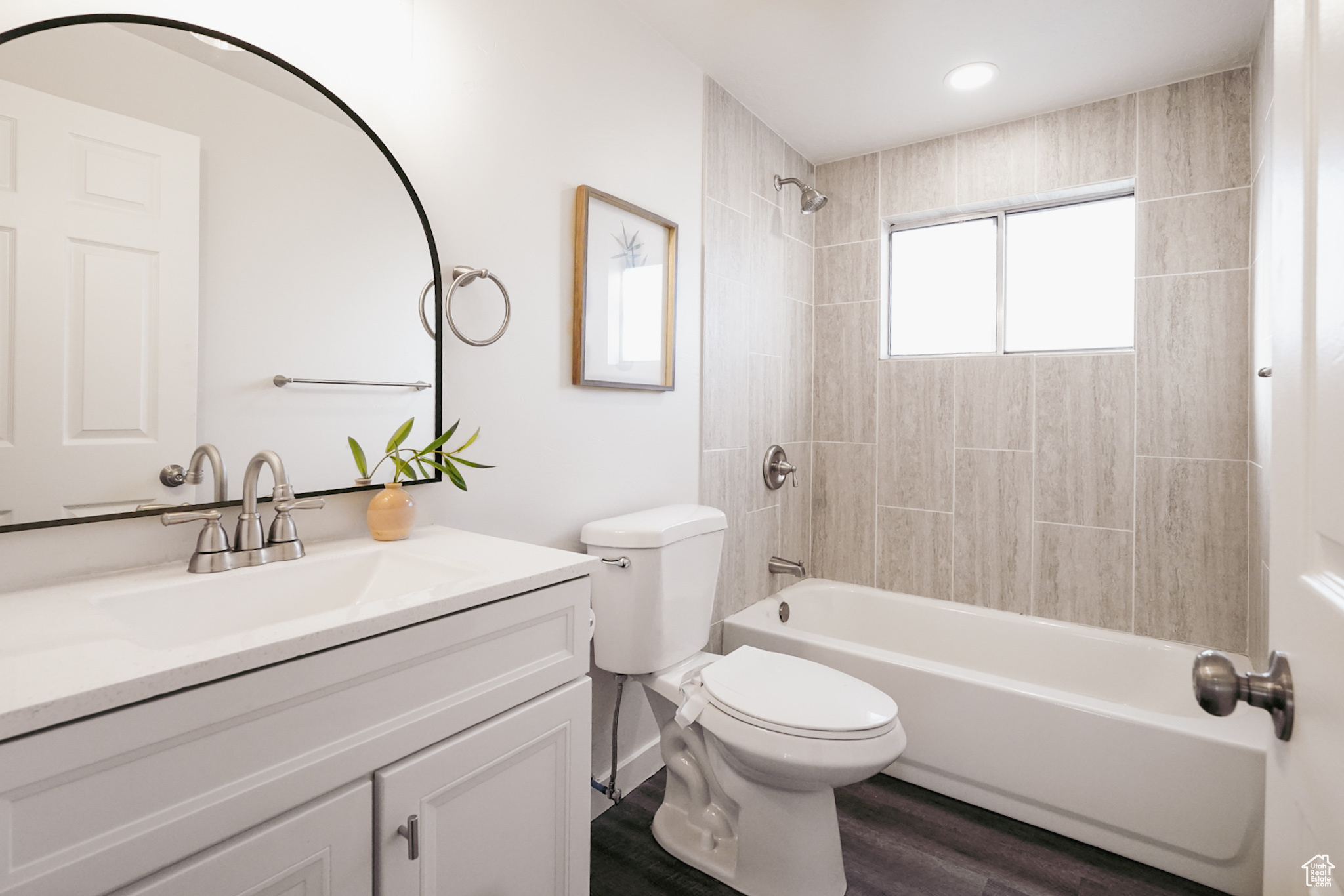 Full bathroom with hardwood / wood-style flooring, vanity, toilet, and tiled shower / bath