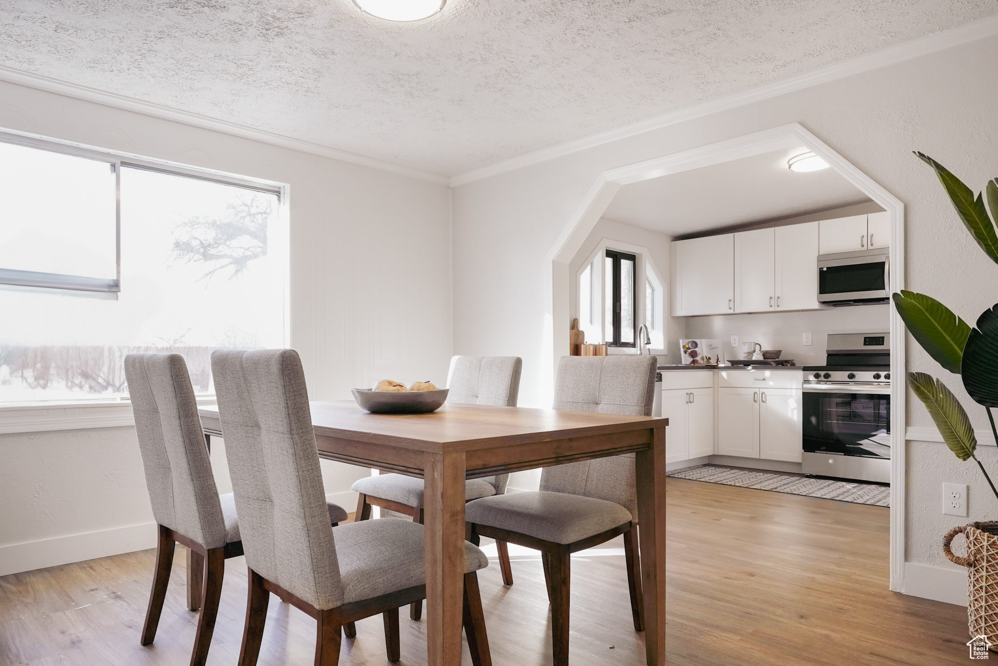 Dining area featuring plenty of natural light, light wood-type flooring, and a textured ceiling