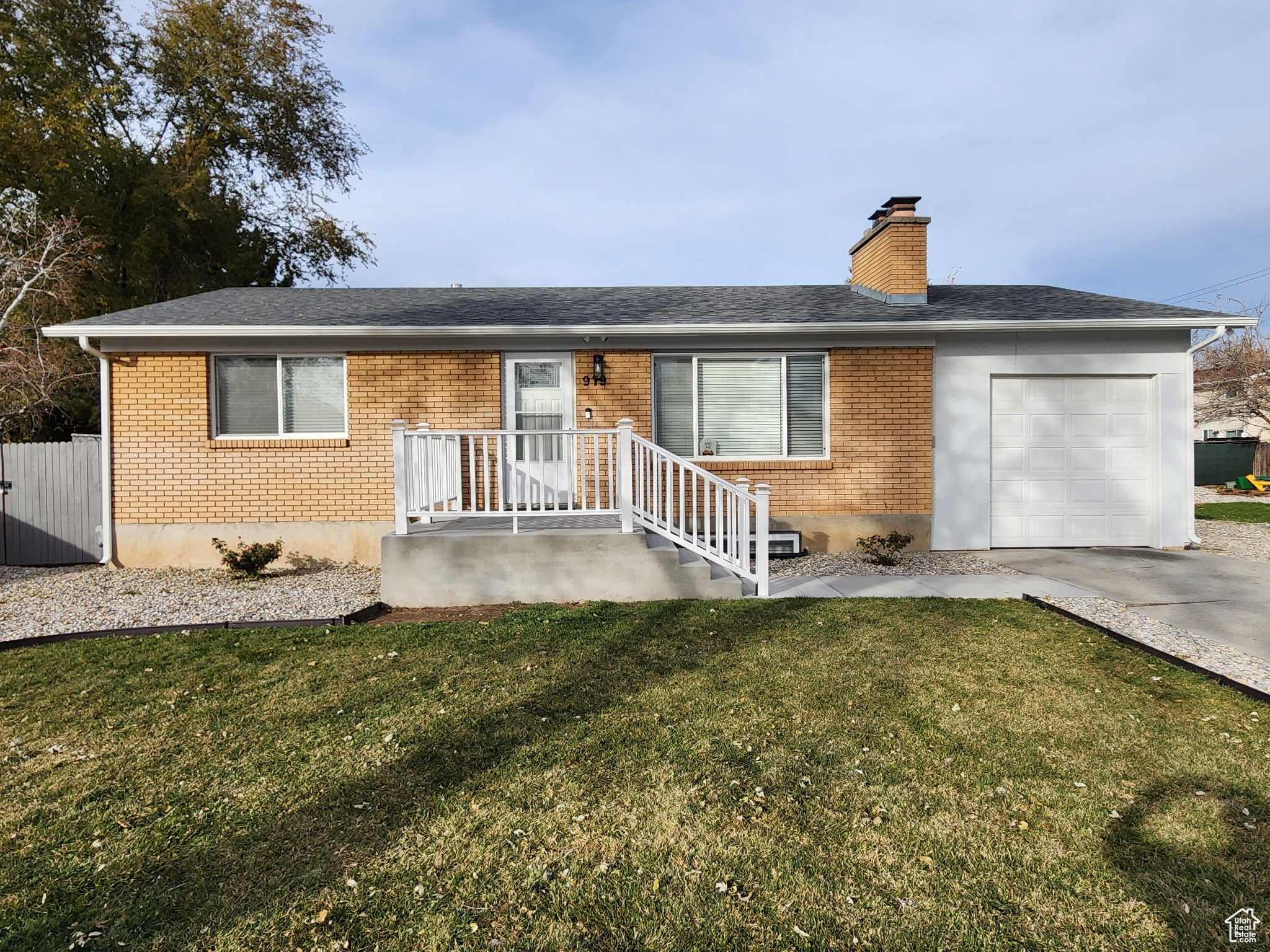 Single story home featuring a garage and a front yard with large lot