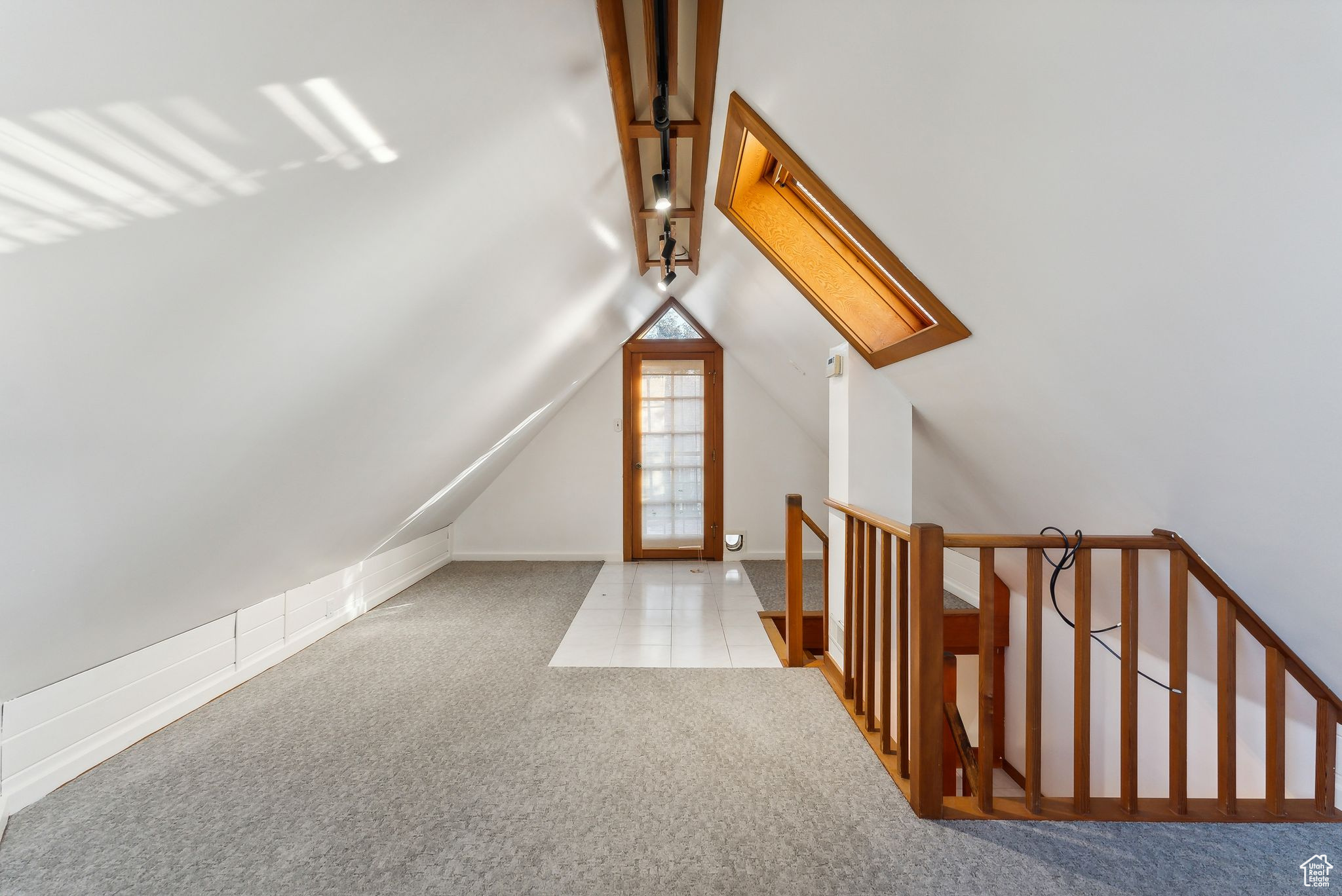 Bonus room with lofted ceiling with skylight and light carpet