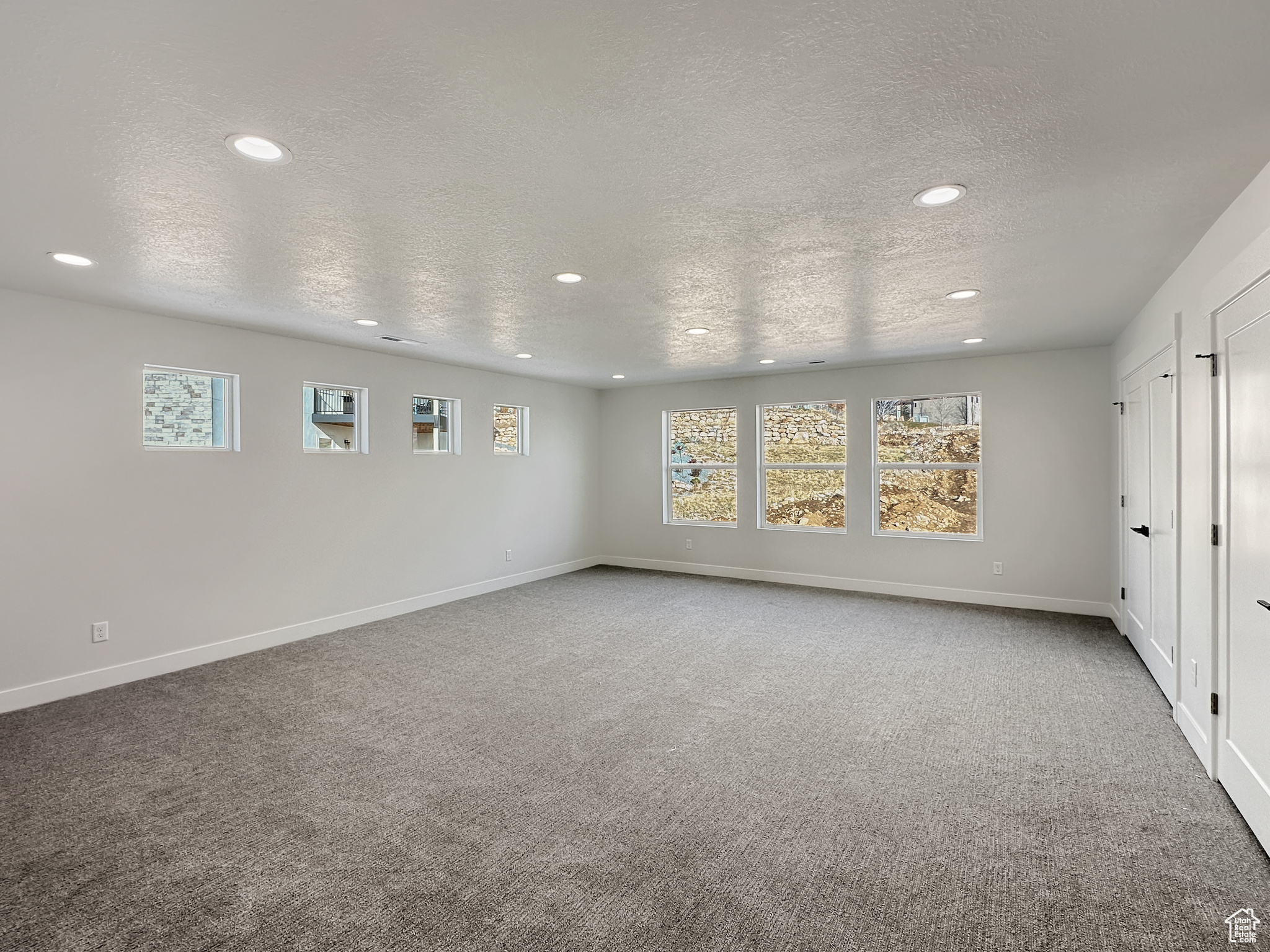 Spare room featuring a textured ceiling and plenty of natural light