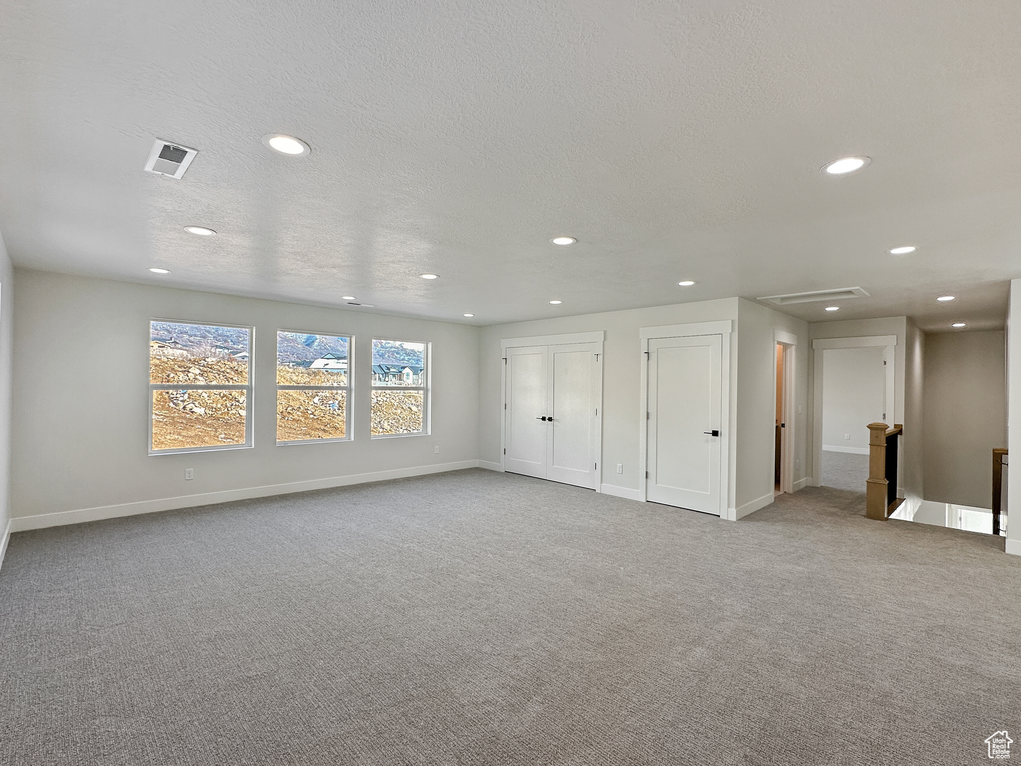 Spare room with light carpet and a textured ceiling