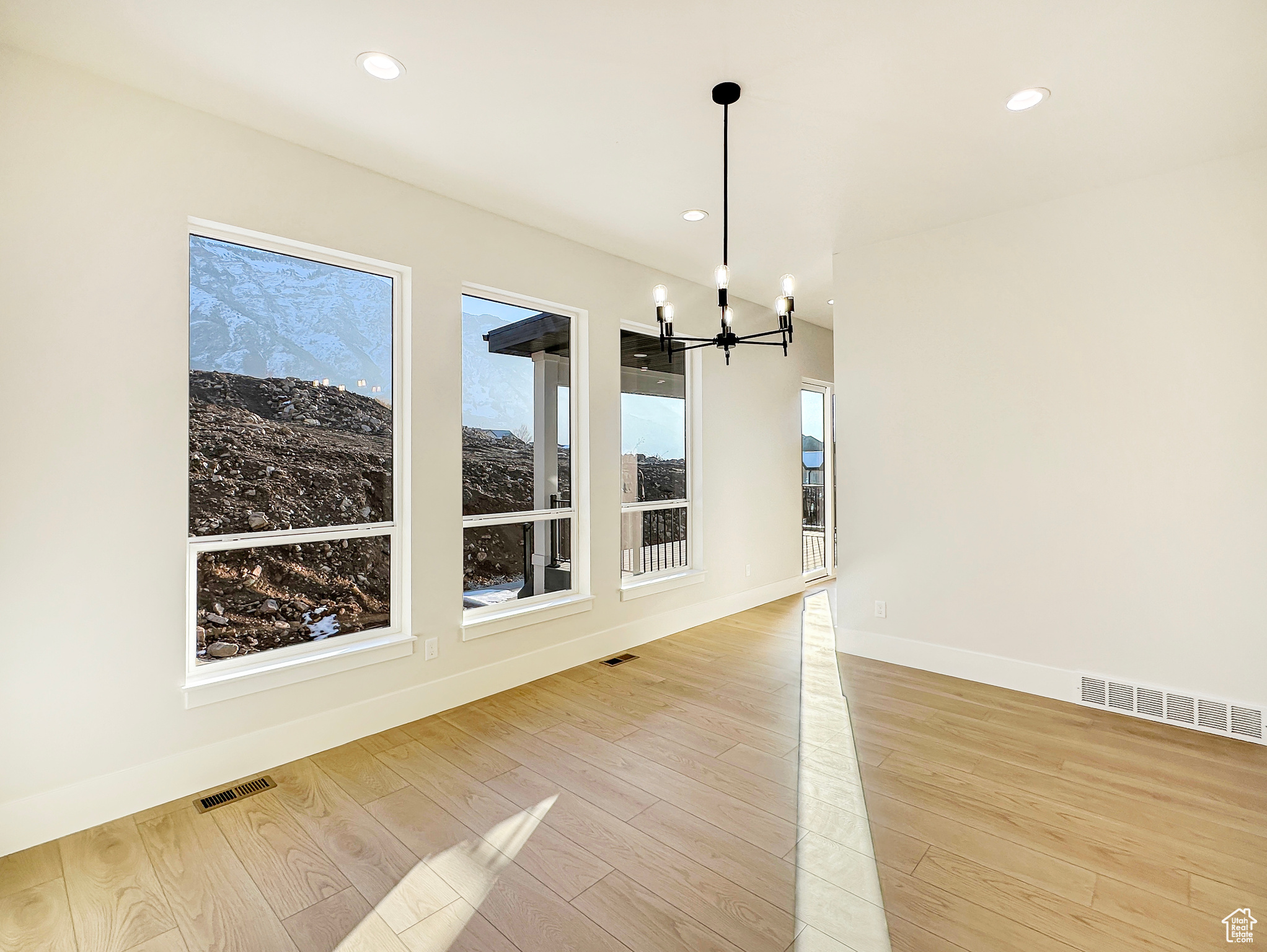 Unfurnished dining area featuring a chandelier and light hardwood / wood-style floors