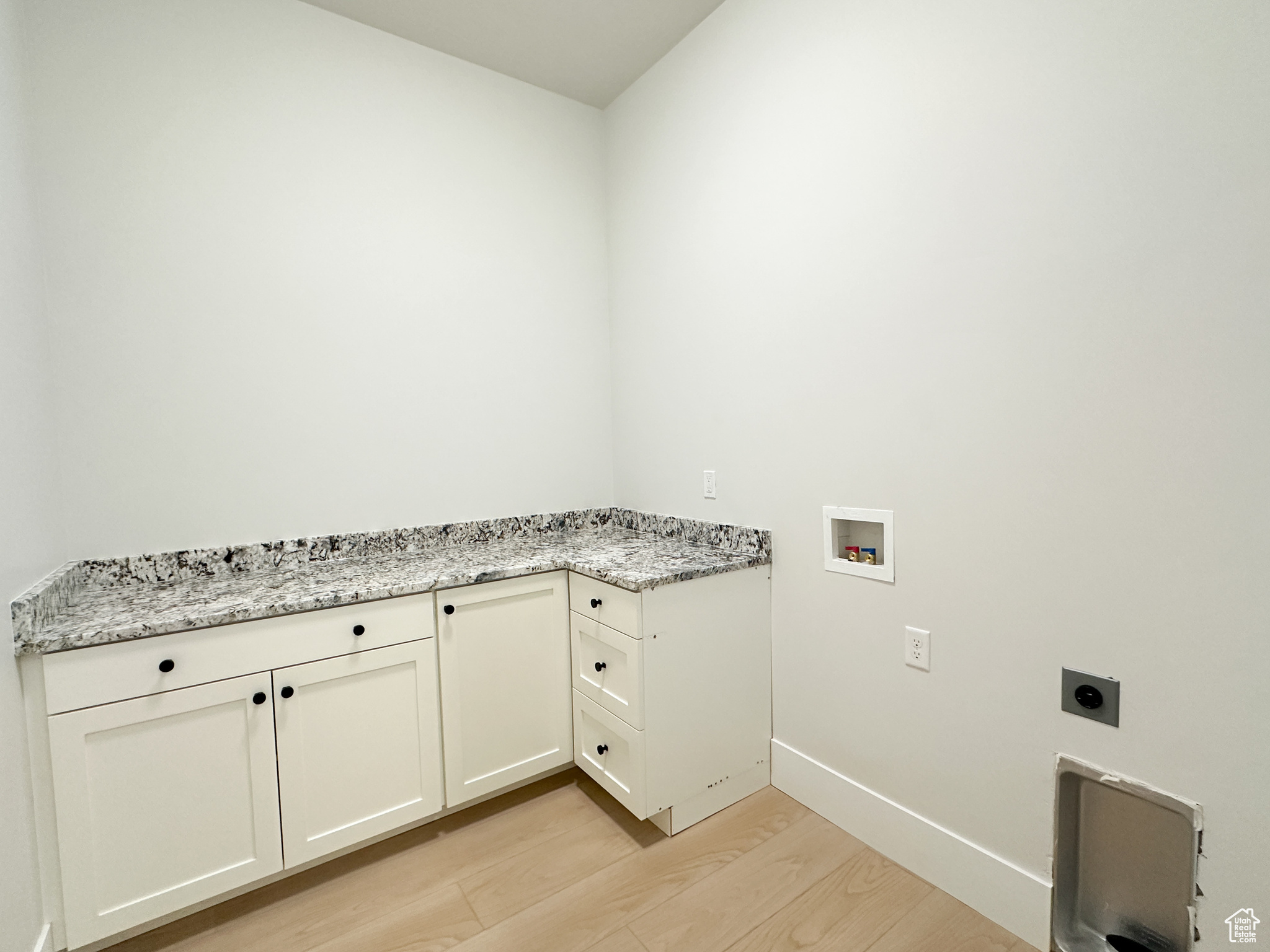 Laundry room with cabinets, hookup for a washing machine, light wood-type flooring, and electric dryer hookup