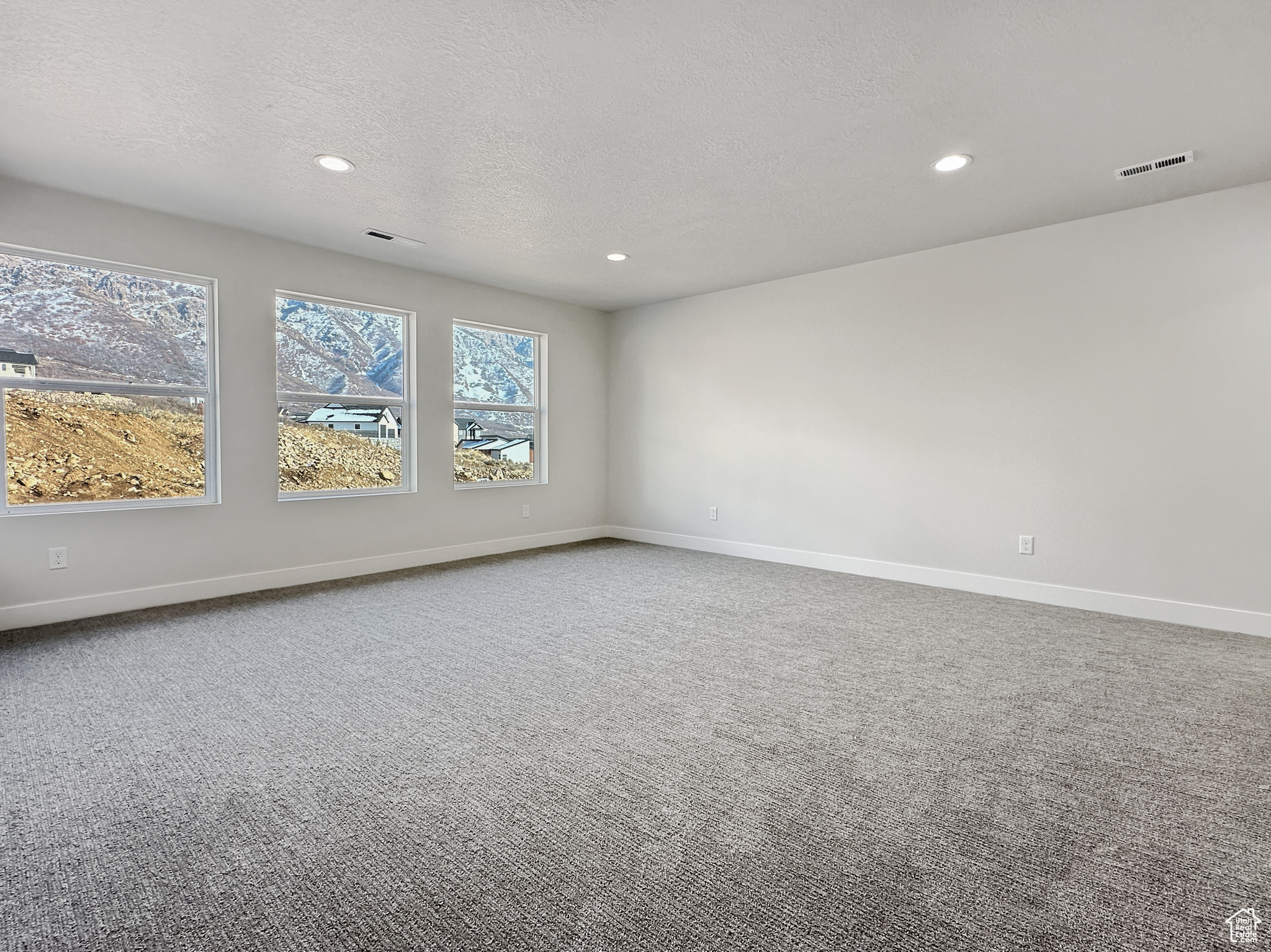 Carpeted spare room featuring a textured ceiling