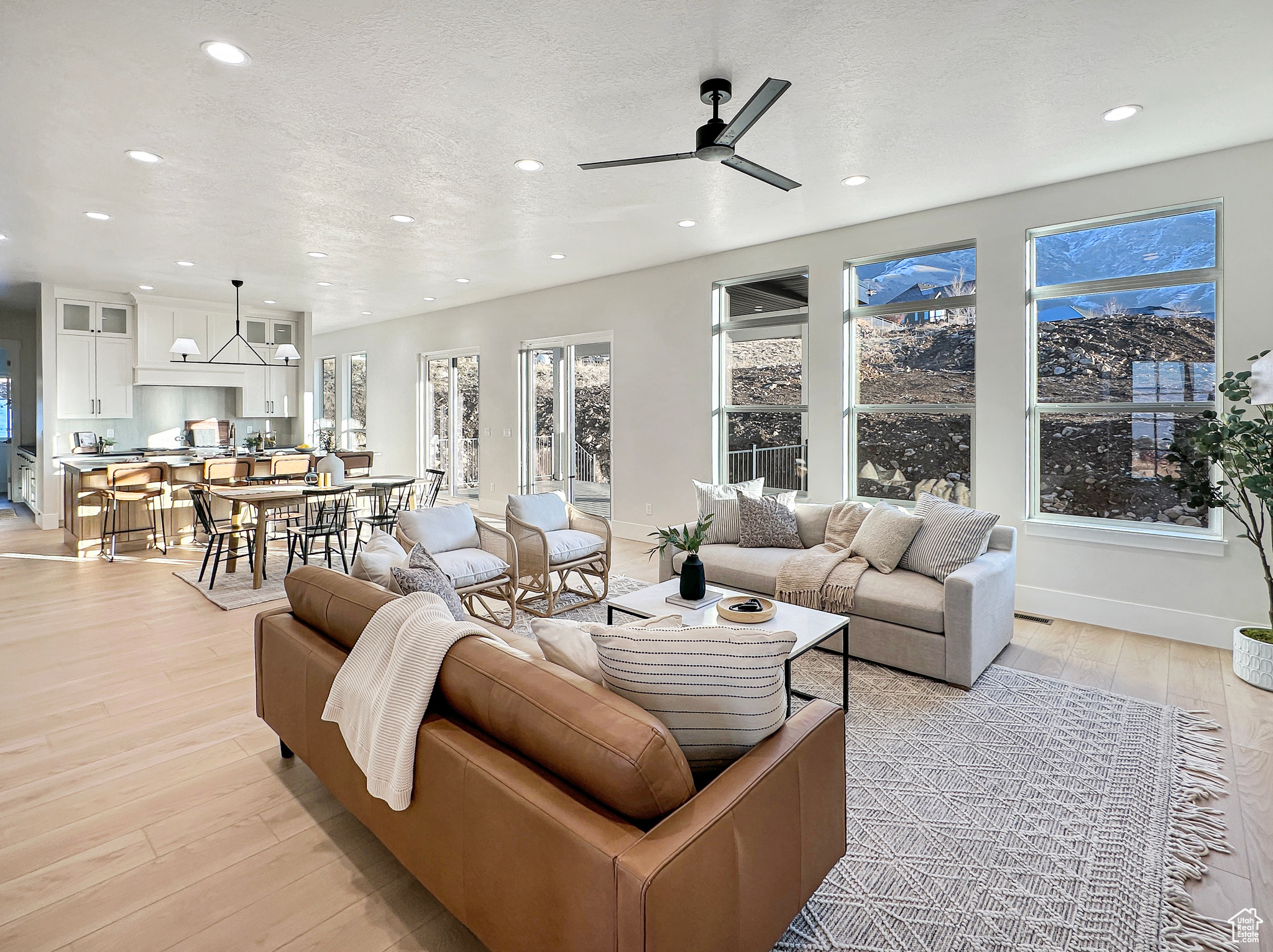 Living room featuring ceiling fan, light hardwood / wood-style flooring, and a textured ceiling