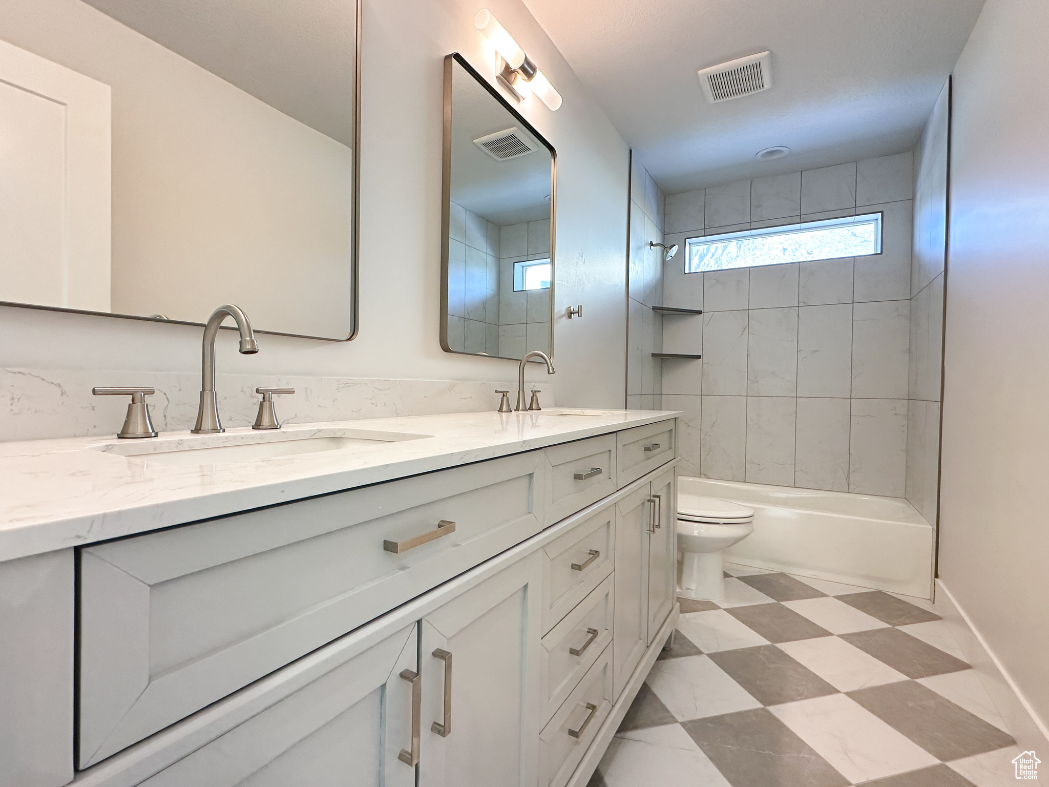 Full bathroom with vanity, tiled shower / bath combo, and toilet