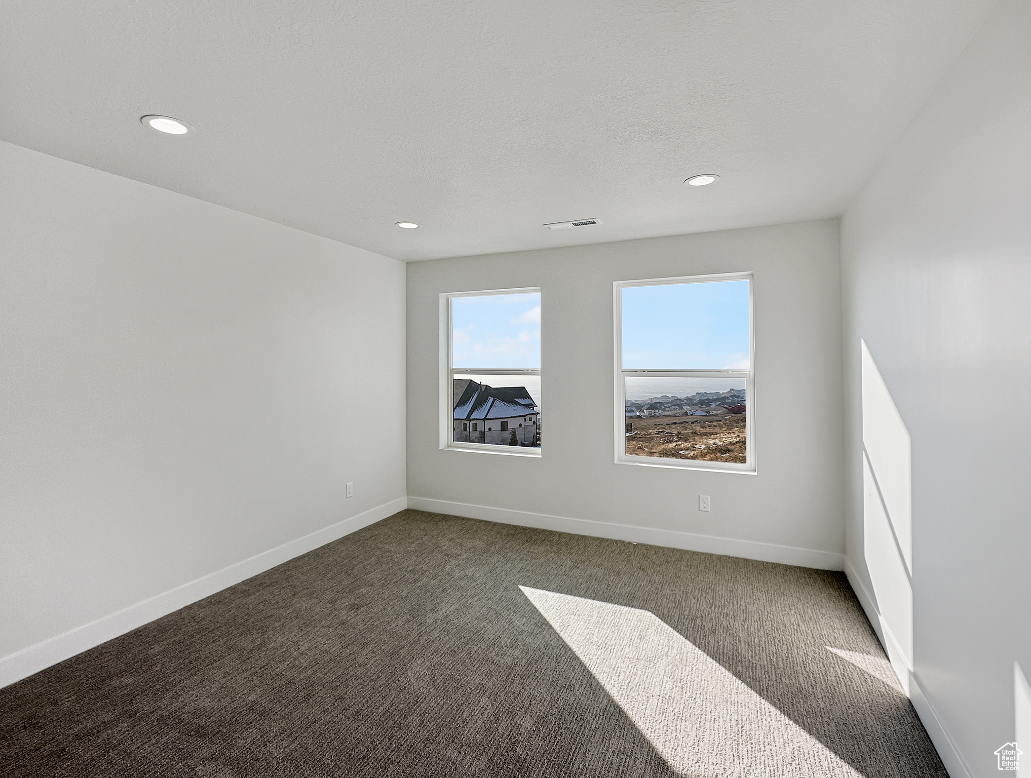 Unfurnished room with dark colored carpet