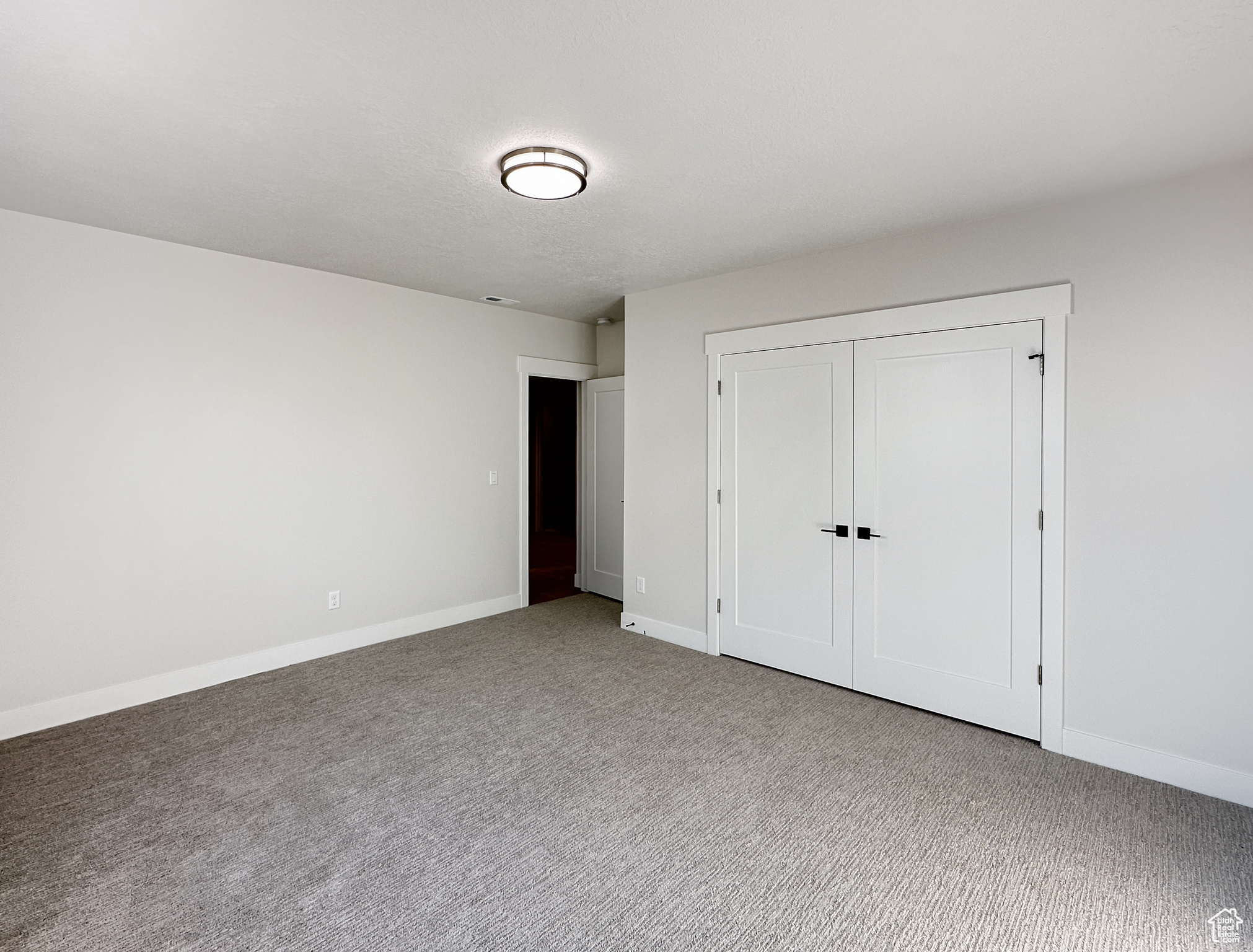 Unfurnished bedroom featuring carpet and a closet