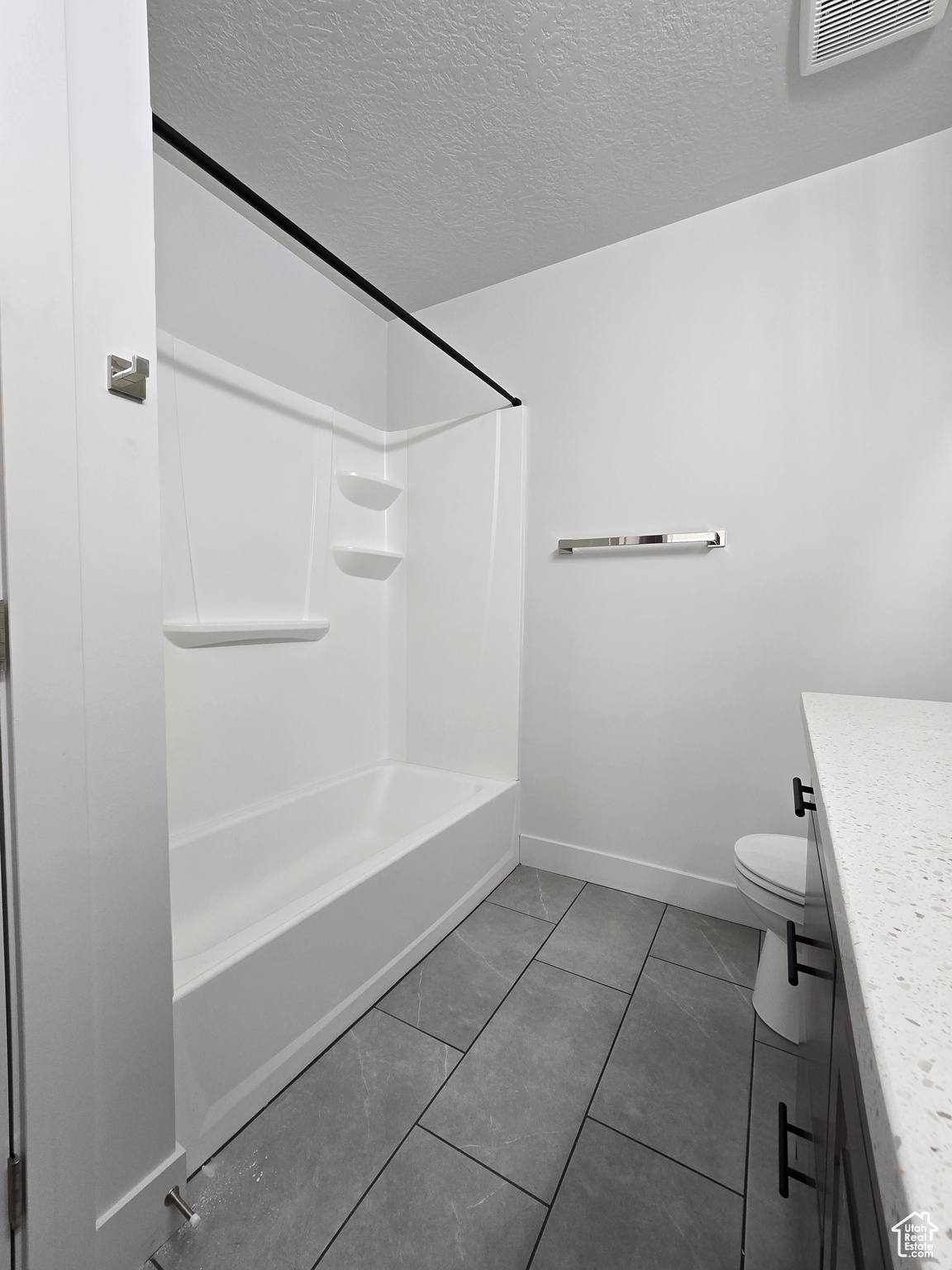 Full bathroom with toilet, a textured ceiling, vanity, and tile patterned floors